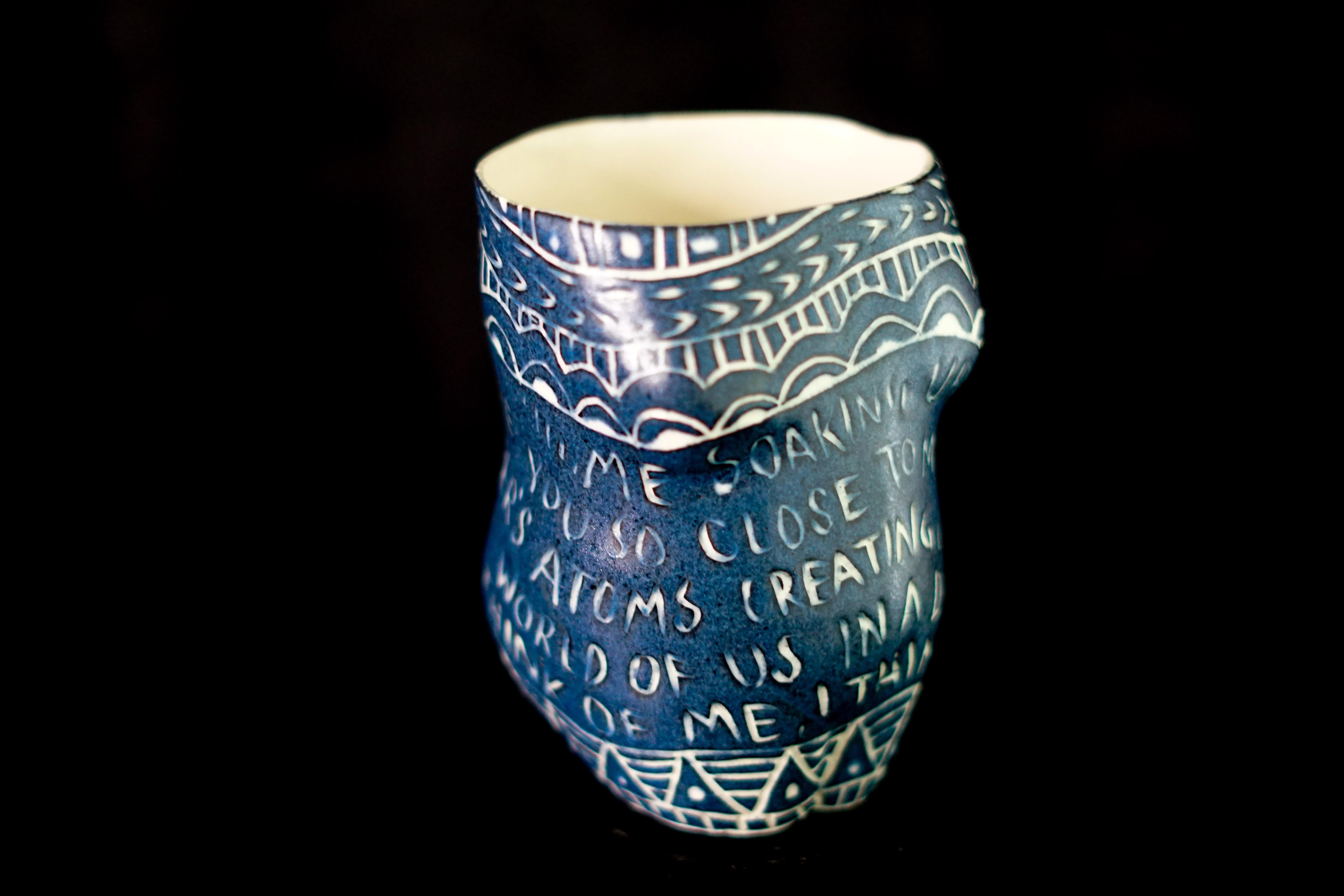 This cup is one of 48 that make up the installation, “Fragments of Our Love Story.” These cups feature feminine forms which recall the Venus of Willendorf and other historical fertility objects. The carvings include many of my own writings and flow