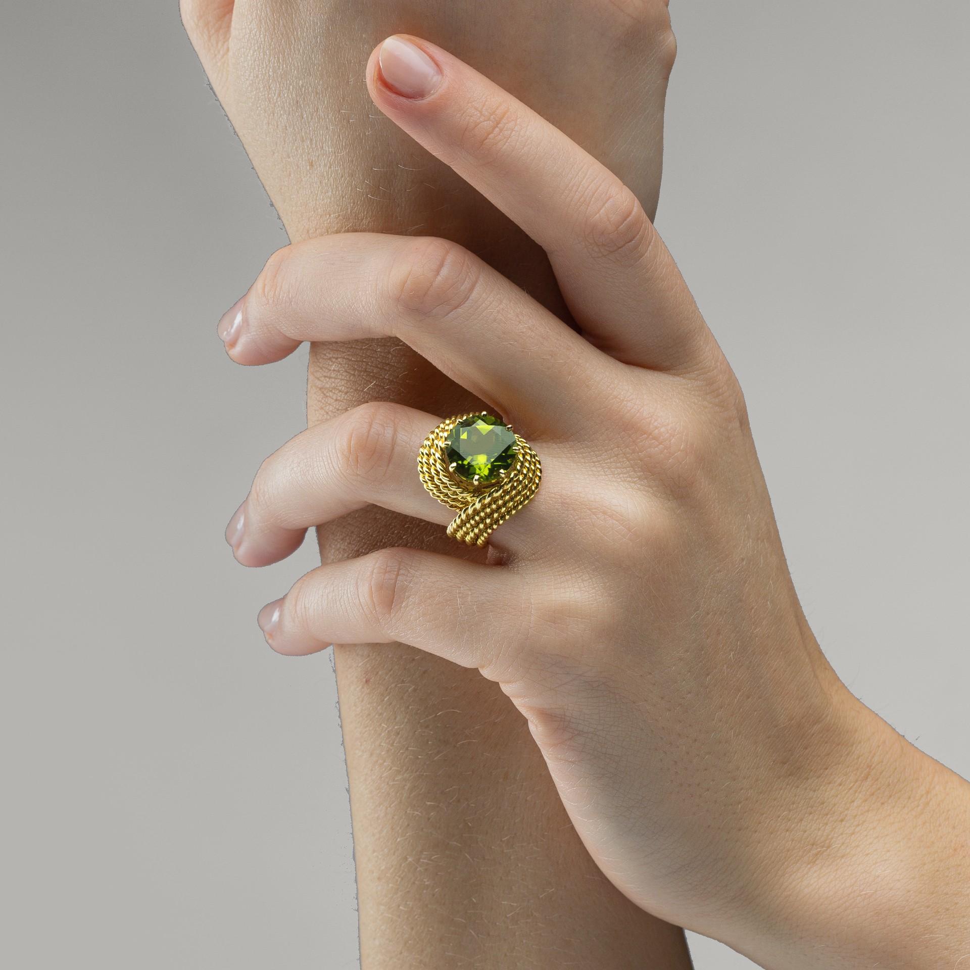 Alex Jona Design-Kollektion, handgefertigt in Italien, Ring Nou Nou aus 18 Karat Gelbgold mit einem Peridot von 3,82 Karat im Rundschliff, umwickelt mit gedrehten Goldfäden.

Die Juwelen von Alex Jona zeichnen sich nicht nur durch ihr besonderes