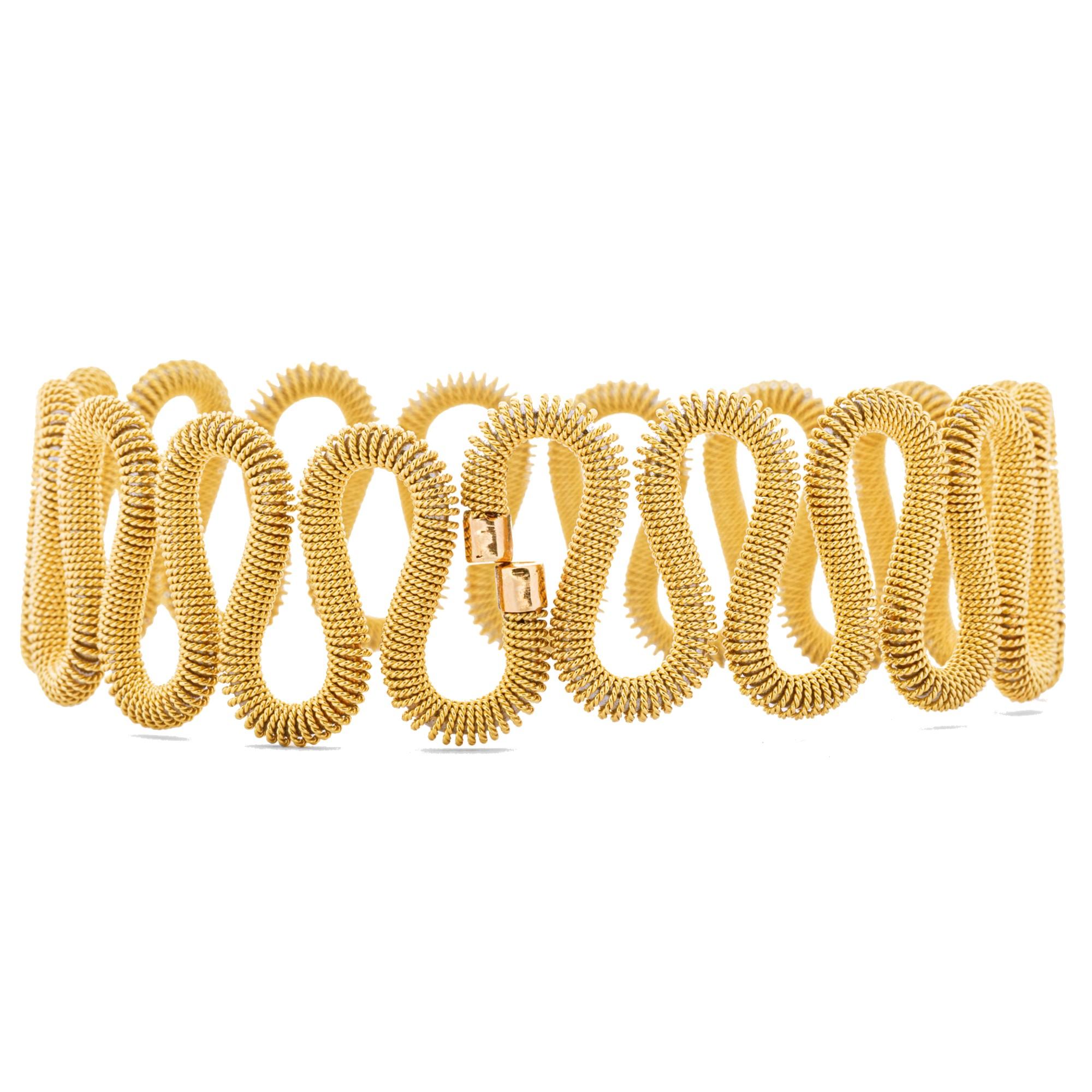 This flexible bangle bracelet has a steel core covered by a twisted 18 Karat yellow gold wire. Designed by Alex Jona and hand crafted in Italy. Width 7cm- 2.76in., Hight 5.5cm-2.16in.
Alex Jona jewels stand out, not only for their special design and