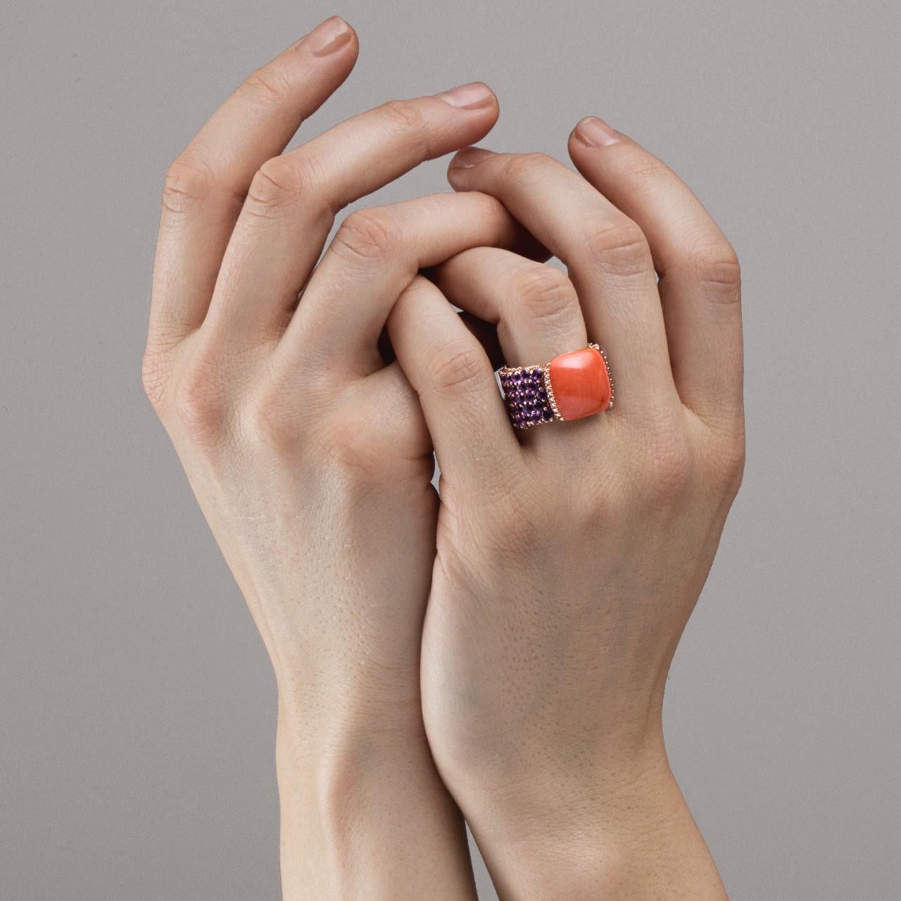 Alex Jona design collection, hand crafted in Italy, 18 carat rose gold band ring centering a Mediterranean Coral Cabochon cushion weighing 9.20ct.. The flexible band is set with 70 Amethysts weighing 5 carats in total. 
Dimensions: H x 26.29mm. Dm x