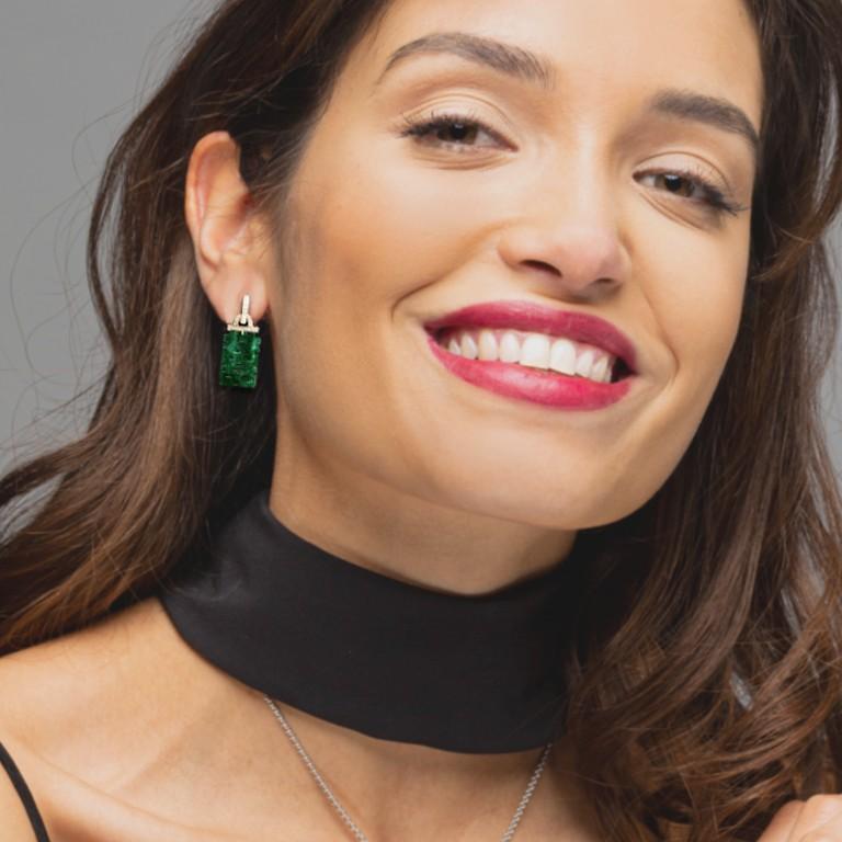 Alex Jona design collection, hand crafted in Italy, pair of 18 karat yellow gold dangle pendant earrings featuring two carved Burmese green jadeite jade weighing 7.61 carat and 48 diamonds weighing 0.25 carats. 
Dimensions : H 1.17 in. x W 0.46 in -