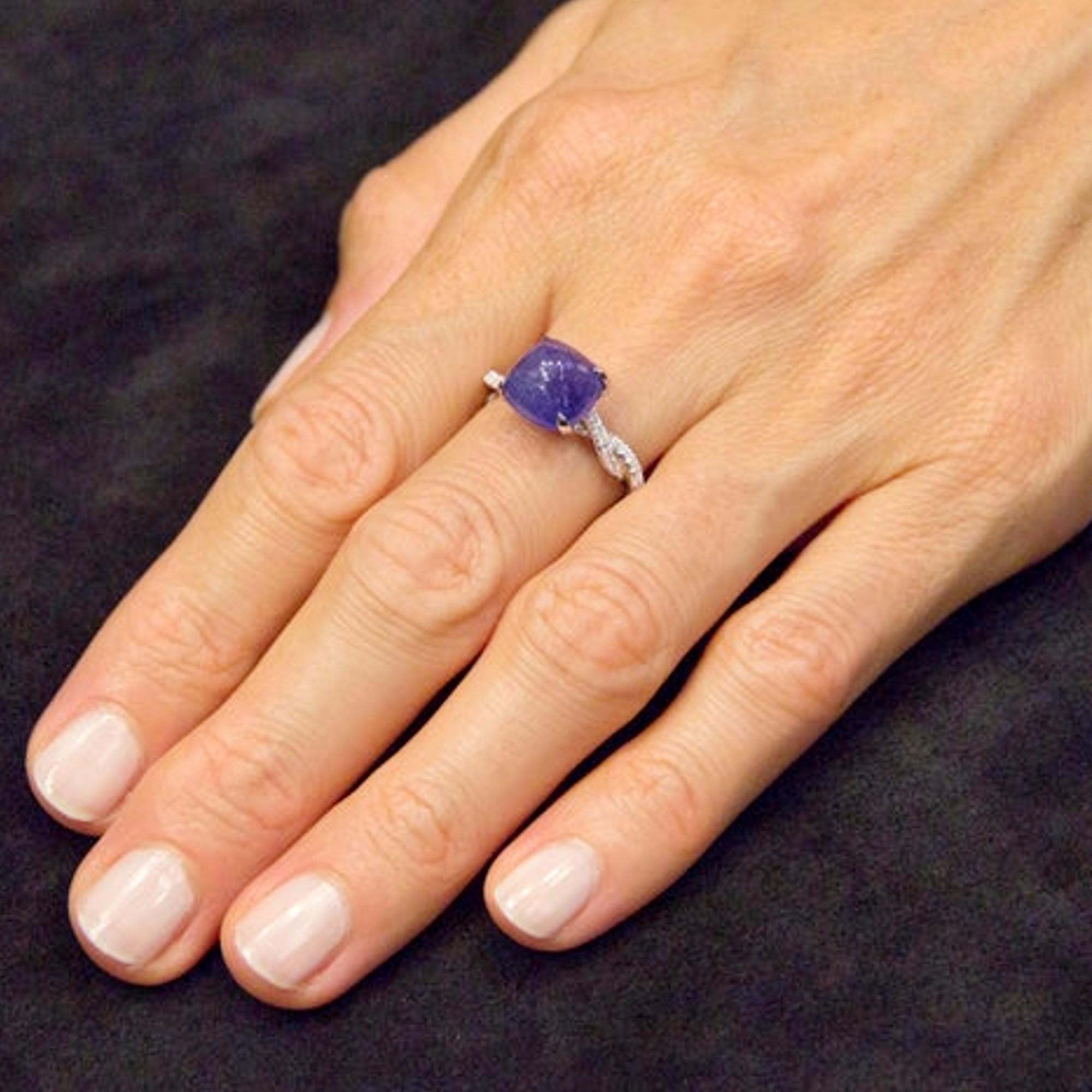 Alex Jona design collection, hand crafted in Italy, 18 karat white gold ring centering a cabochon Tanzanite weighing 6.32 carats. The shoulders are set with 84 White diamonds weighing 0.40 carats in total, F color, VVS1 clarity.
Dimensions: 1.18 in.