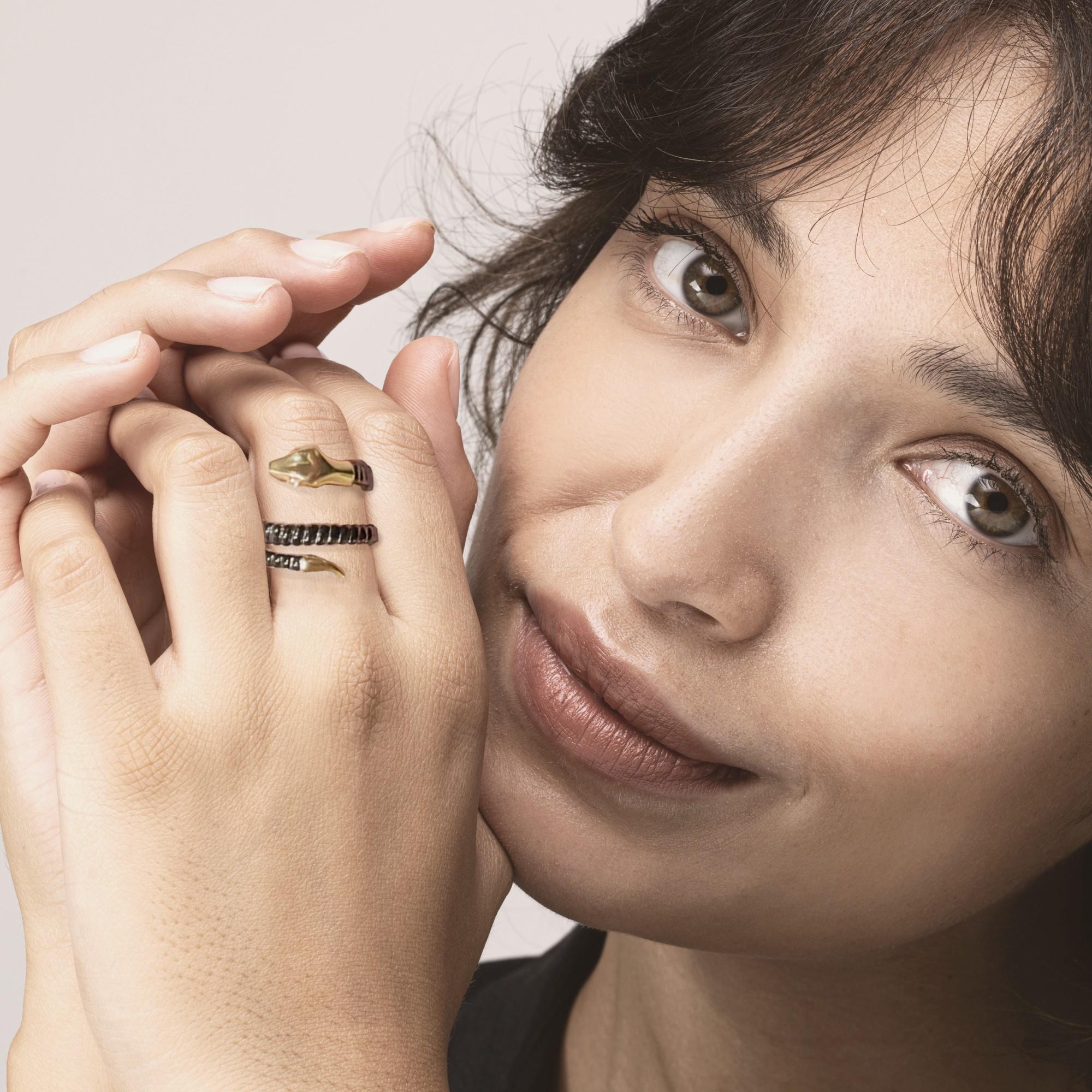 Colección de diseño Alex Jona, anillo serpiente flexible, el cuerpo enroscado de plata de ley negra está unido a una cola y una cabeza de oro amarillo de 18 quilates, dos ojos de diamantes blancos talla brillante. 

Las joyas de Alex Jona destacan