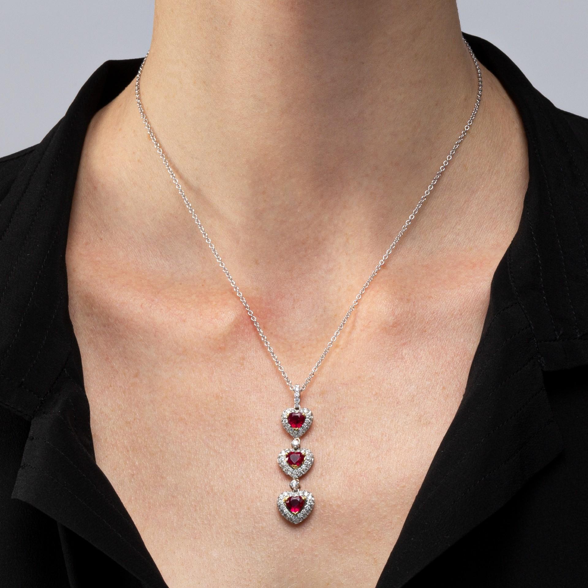 Alex Jona design collection, hand crafted in Italy, 18 karat white gold pendant centering three heart cut rubies weighing 2.88 carats in total surrounded by 0.89 carats of white diamonds, F color, VVS1, suspending from a 16.5 inch long 18 karat