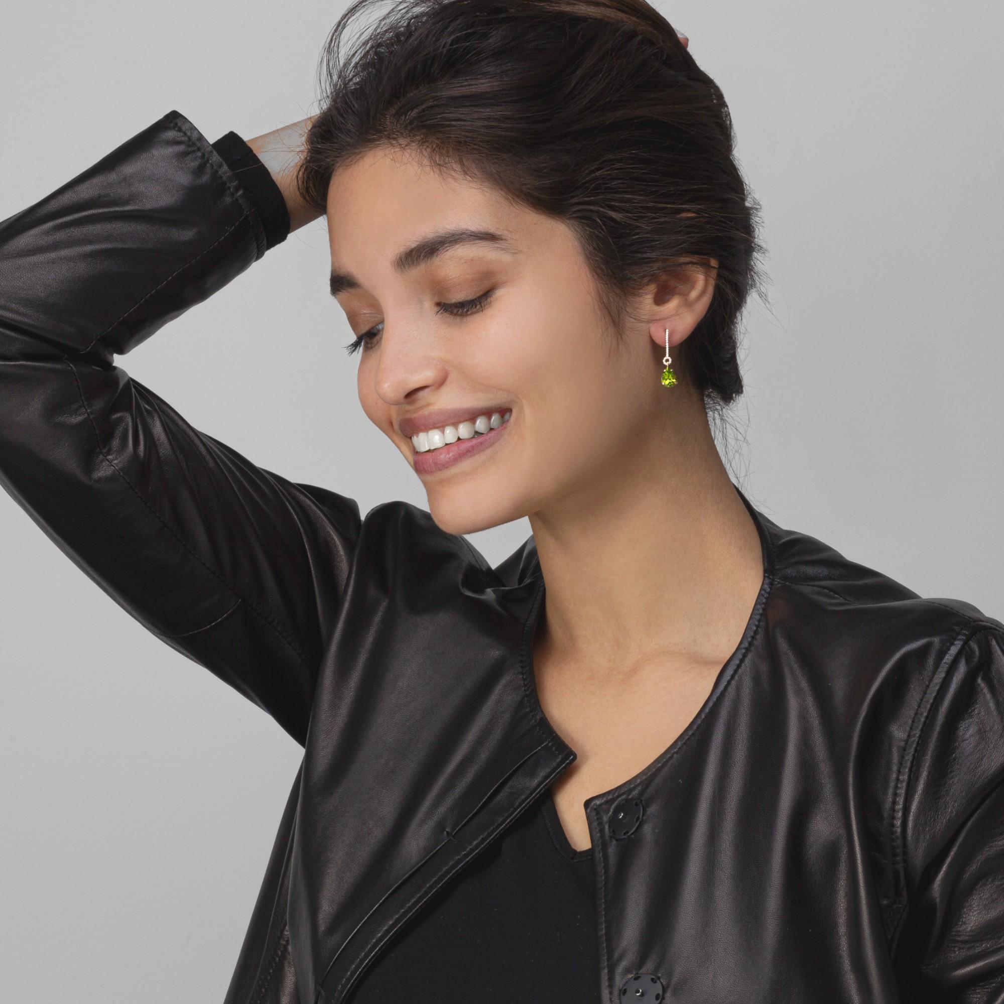 Alex Jona design collection, hand crafted in Italy, 18 karat yellow gold drop earrings set with 0.14 carats of white diamonds, F color, VVS1 clarity, suspending two drop cut peridots weighing 3.88 carats. 

Alex Jona jewels stand out, not only for