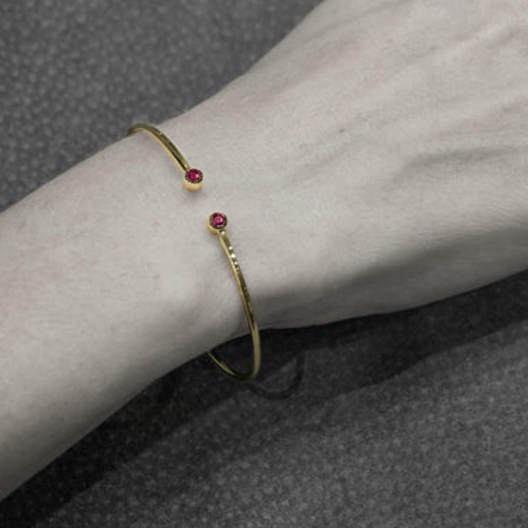Alex Jona design collection, hand crafted in Italy, 18 karat yellow gold bangle bracelet set with two round cut natural rubies weighing in total 0.31 carats.
Dimensions: 
2.09 in. H x 2.32 in. W x 0.14 in. D
53 mm. H x 59 mm. W x 4 mm. D

Alex Jona