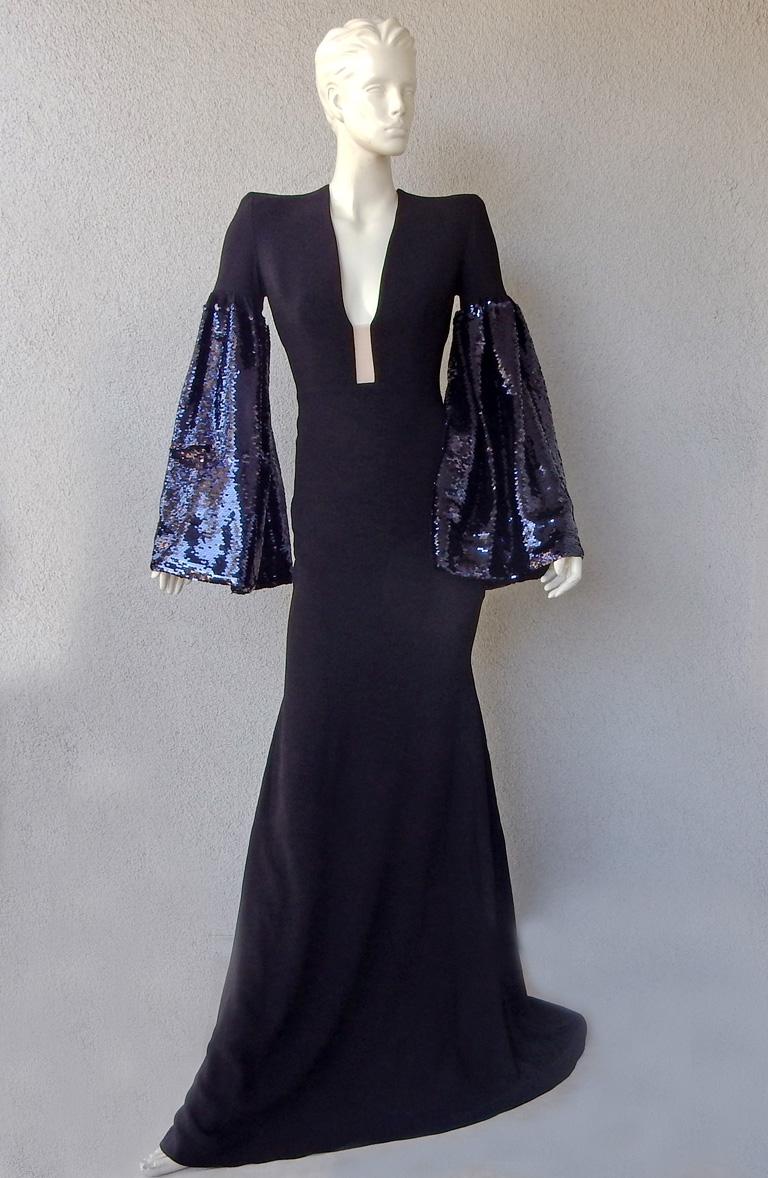 Stunning sell out Alex Perry gown offered in brand new condition.   Gown is black accented by blue sequin lantern sleeves.  Nude insert in center front with padded shoulders.    Sheath style silhouette with dramatic swan-tail train.   A fabulous