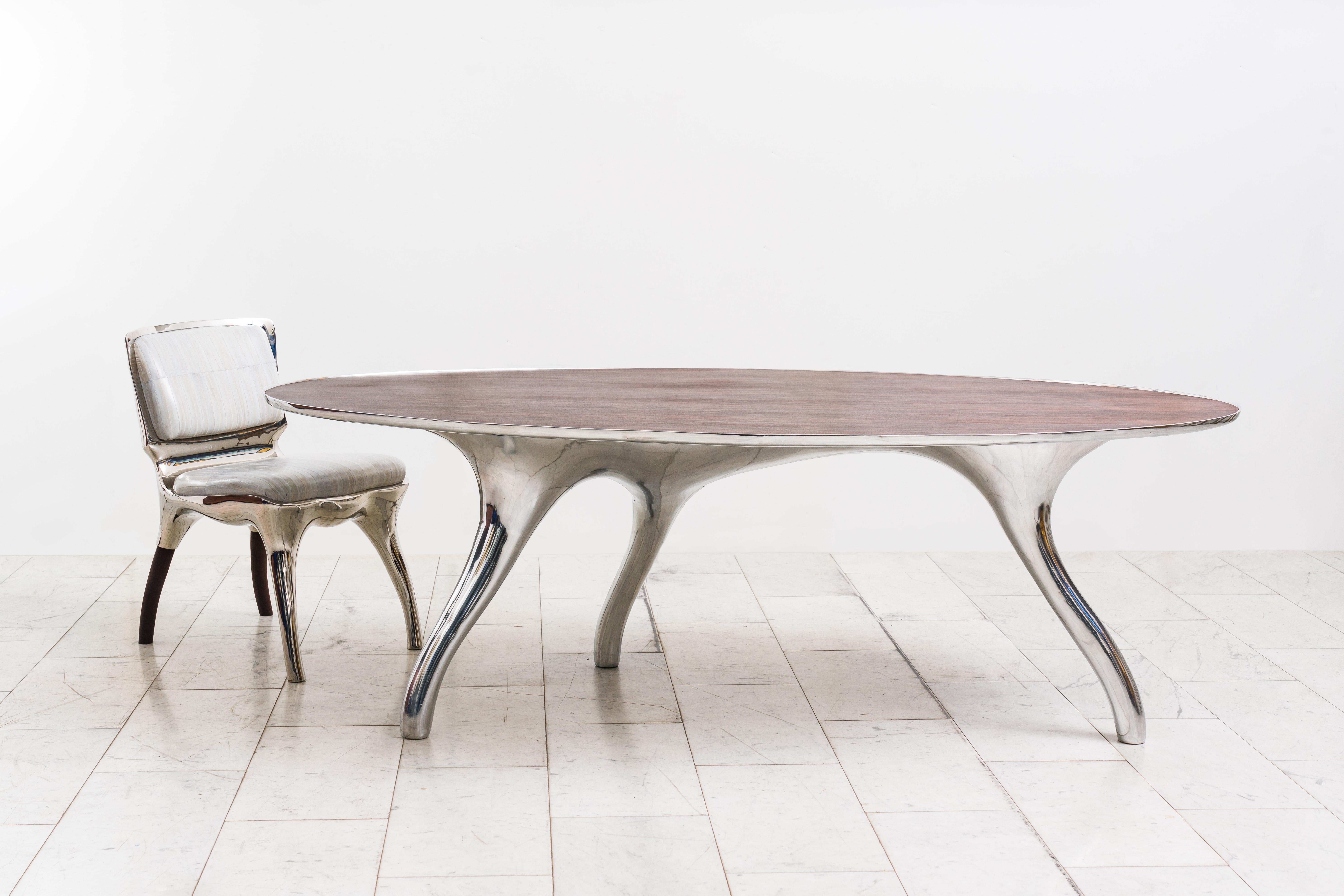 Alex Roskin’s Trois Jambes table with Bezel top can easily function as a desk or dining table. Resting on a sparkling tripod base of mirror-polished stainless steel, the table is an ideal option for unique spaces. Available by commission, the table