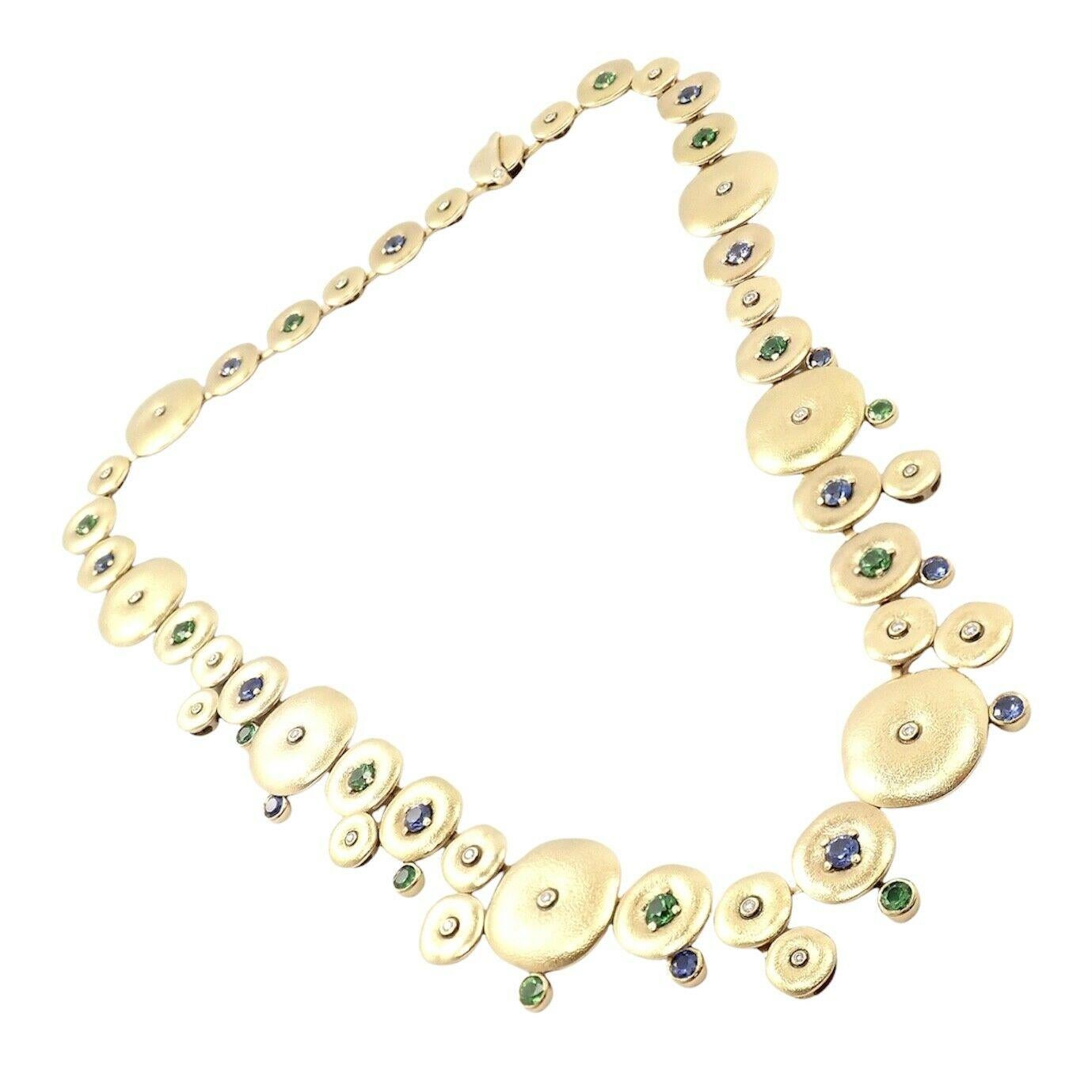 Diese schöne Halskette aus 18 Karat Gelbgold stammt vom Designer Alex Sepkus. 
Mit 14x Tsavorit (2,20ct)
14x Saphire (2,20 Karat)
24x Diamanten (0,30ct)
NUMBERED #29
Abmessungen: 
Die breiteste Scheibenscheibe: 15 mm
Gesamtlänge: 17 Zoll