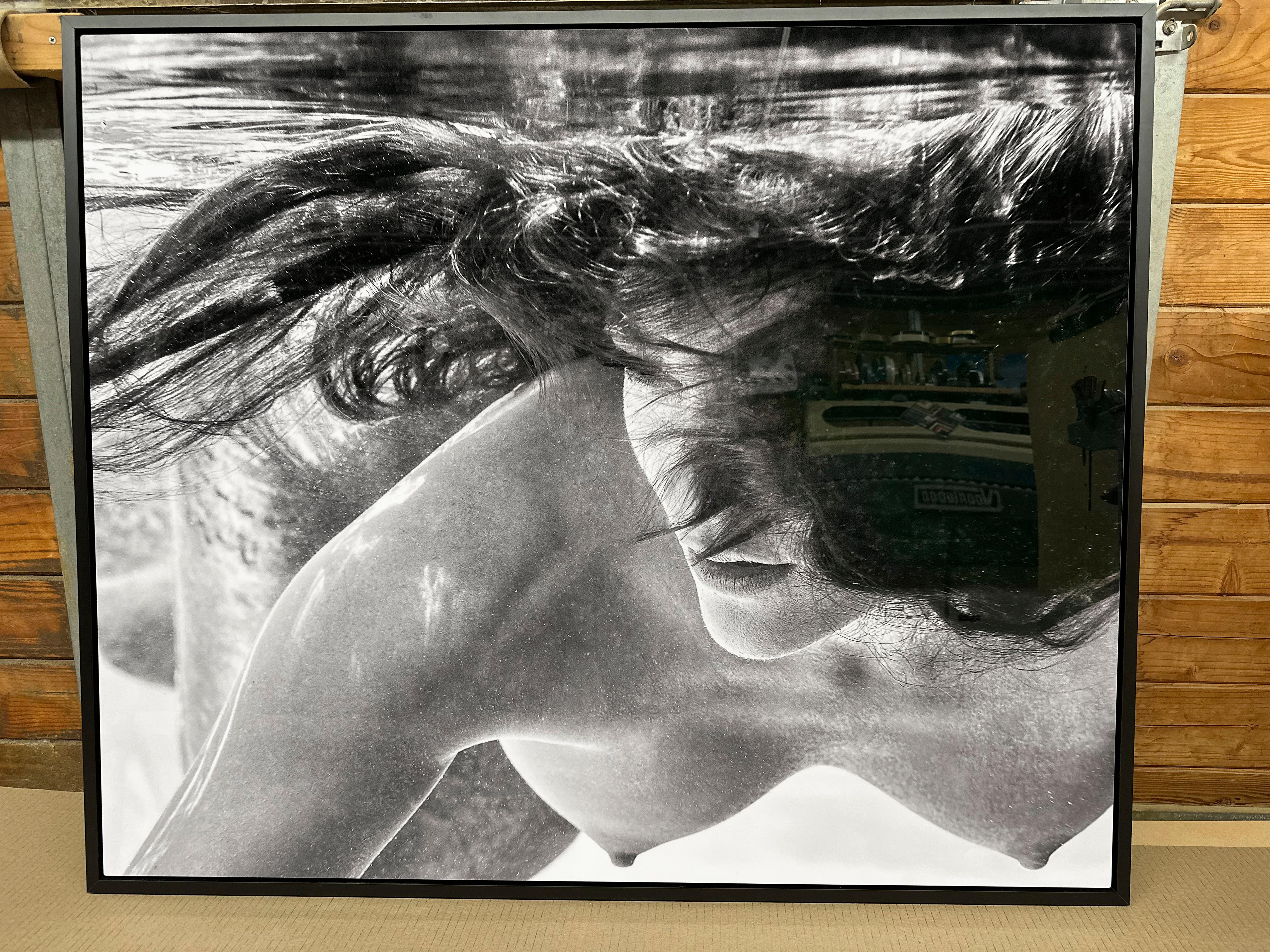 An underwater black and white photograph of a beautiful topless young woman, Apriel swimming in the pool. 

Original digital print on aluminum plate signed by the artist.
Limited edition of 12, print #2.
The artwork is furnished with certificate of