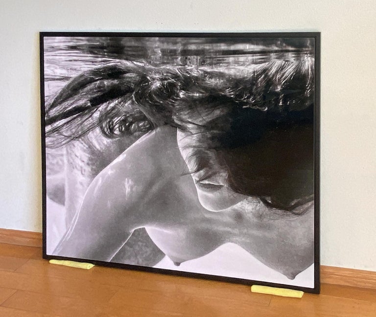 An underwater black and white photograph of a beautiful topless young woman, Apriel swimming in the pool. 

Original digital print on aluminum plate signed by the artist.
Limited edition of 12, print #2.
The artwork is furnished with certificate of