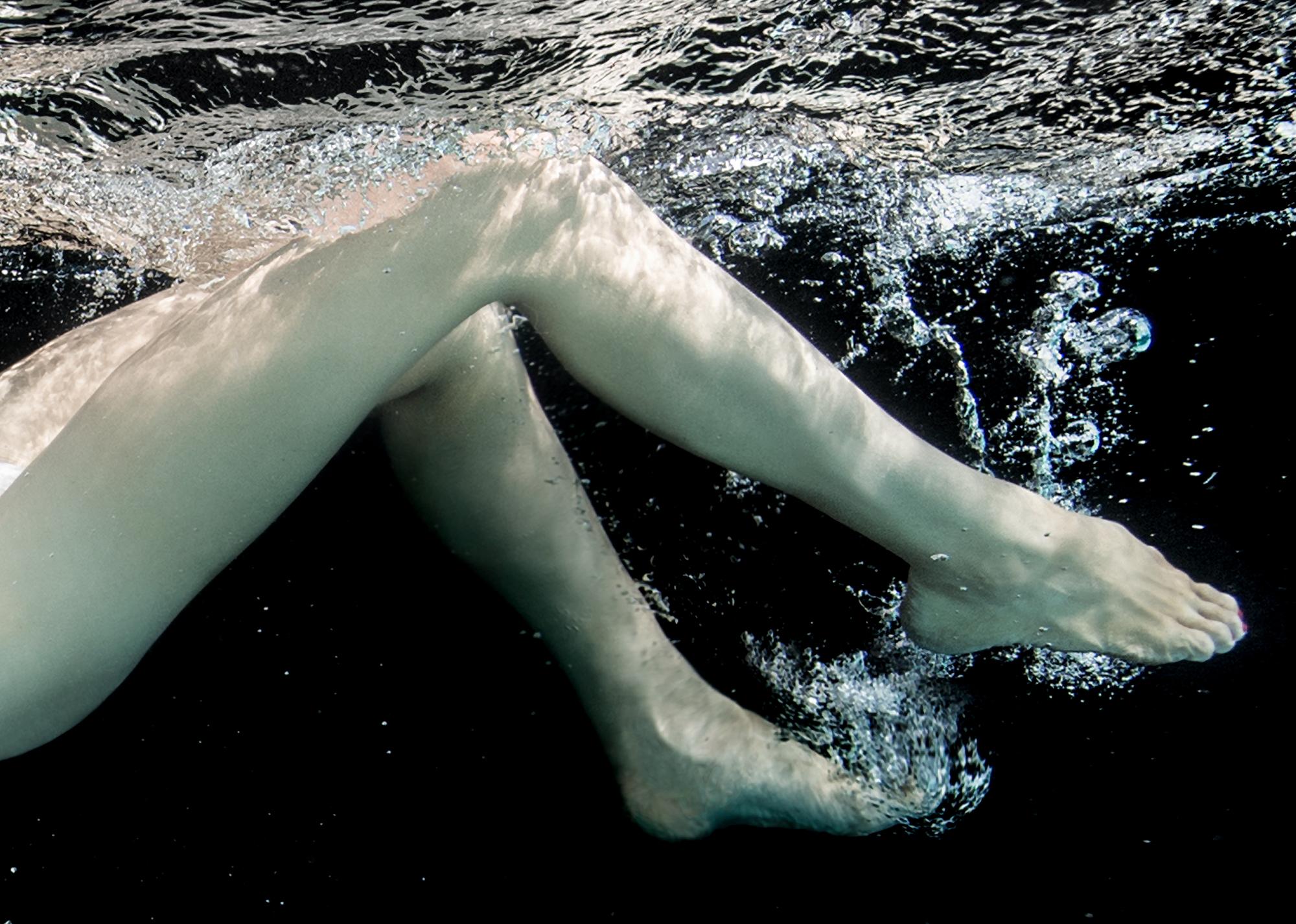 Unterwasser-Schwarz-Weiß-Foto einer jungen Tänzerin beim Tauchen im Pool. Die nackten Tänzerinnen bedecken sich mit einem Tutu-Rock.

Originaldruck auf Aluminiumplatte mit fester schwarzer Rückwand. Das Kunstwerk braucht keine zusätzliche Rahmung: