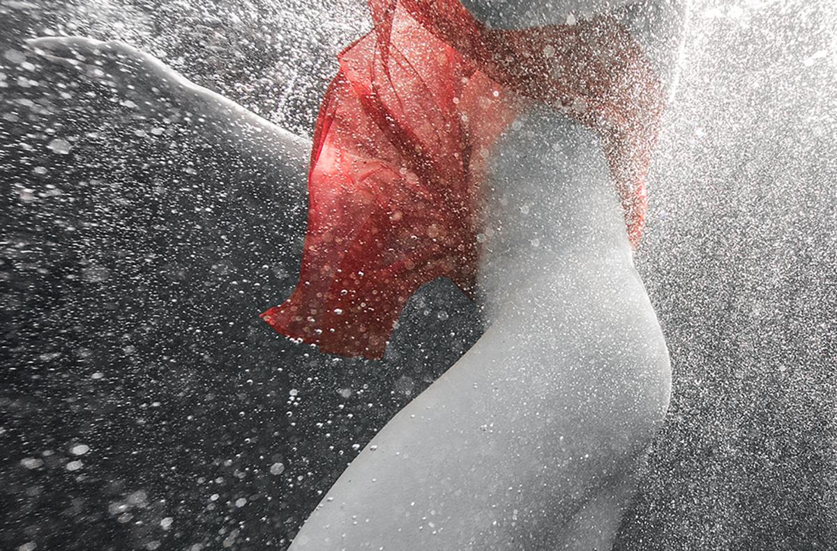 An underwater photograph of a dancer in short red dress dancing in air bubbles.
 
Original gallery quality print signed by the artist. 
Digital archival pigment print on archival paper with metallic finish. 
Limited edition of 24
The artwork is