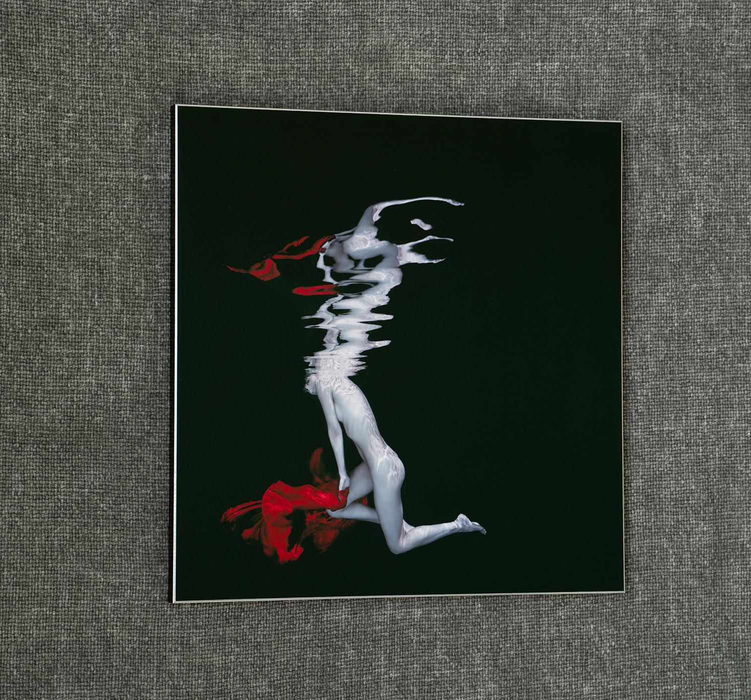 Photo sous-marine de la chanteuse russe Katya Lee. La photographie minimaliste est essentiellement en noir et blanc, à l'exception de l'écharpe en forme de cerise.

Épreuve originale sur plaque d'aluminium avec fond noir solide. L'œuvre d'art ne