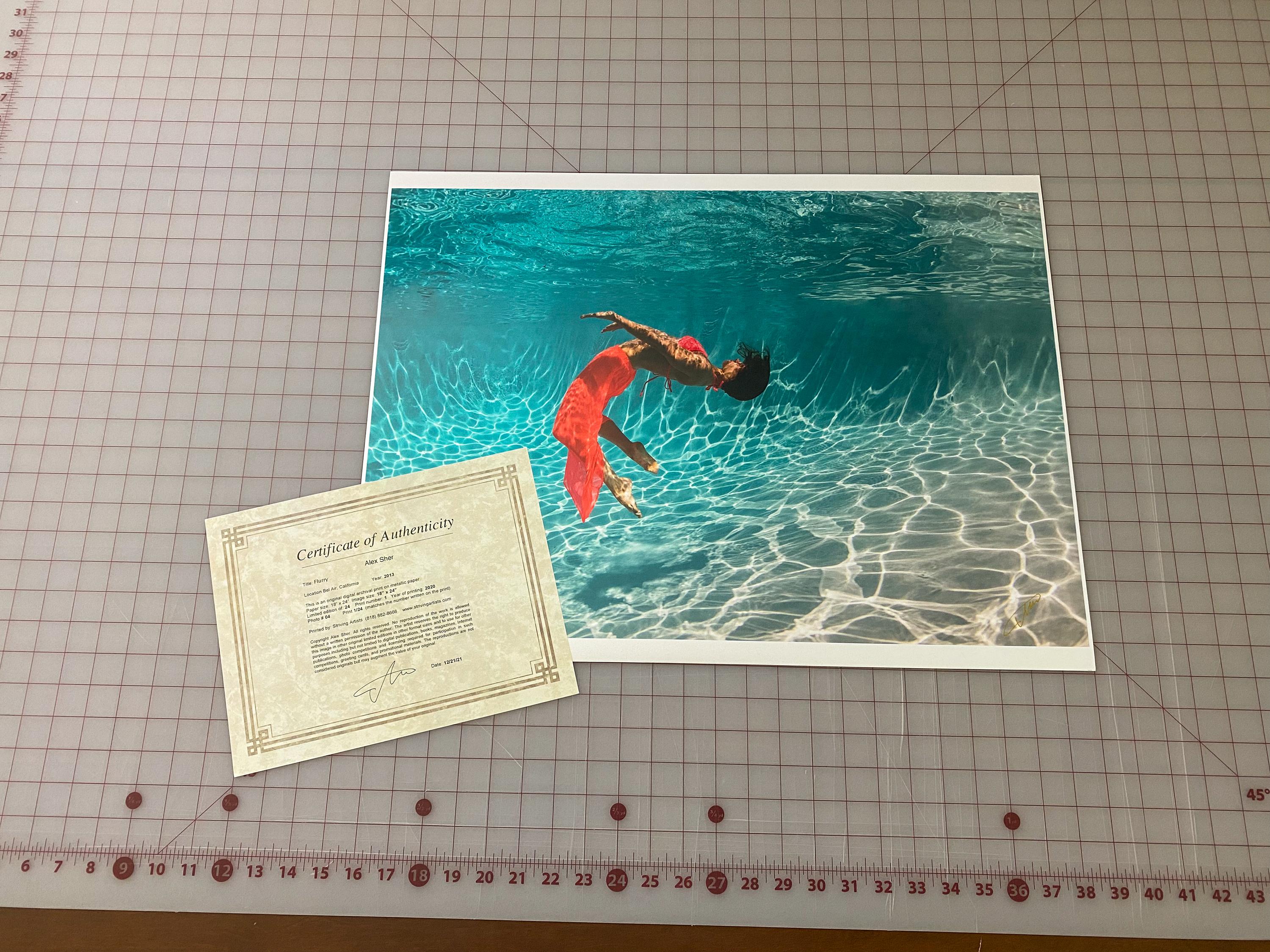 Underwater photograph of a young woman in red dress dancing underwater in a pool. A very bright photograph with plenty of sun and positivity.

Model: a Russian dancer Olga Sokolova.  Check out her performance 