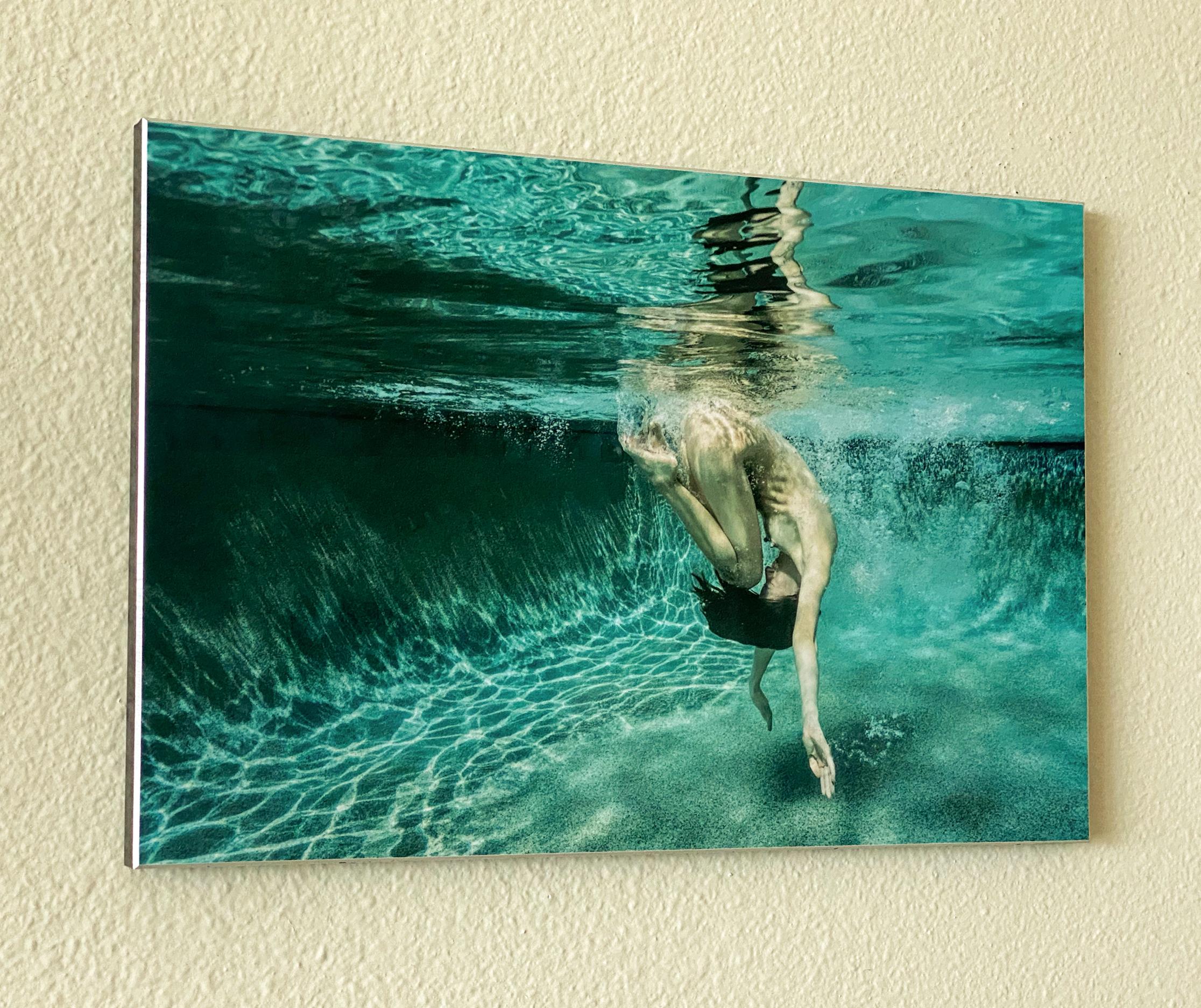 Unterwasseraufnahme einer nackten jungen Frau, die in einem Schwimmbecken taucht (rollt). Diese äußerst dynamische Fotografie ist reich an Grüntönen und sieht abstrakt aus, während sie in Wirklichkeit ganz figurativ ist.
Dieses Foto ist der Teil II