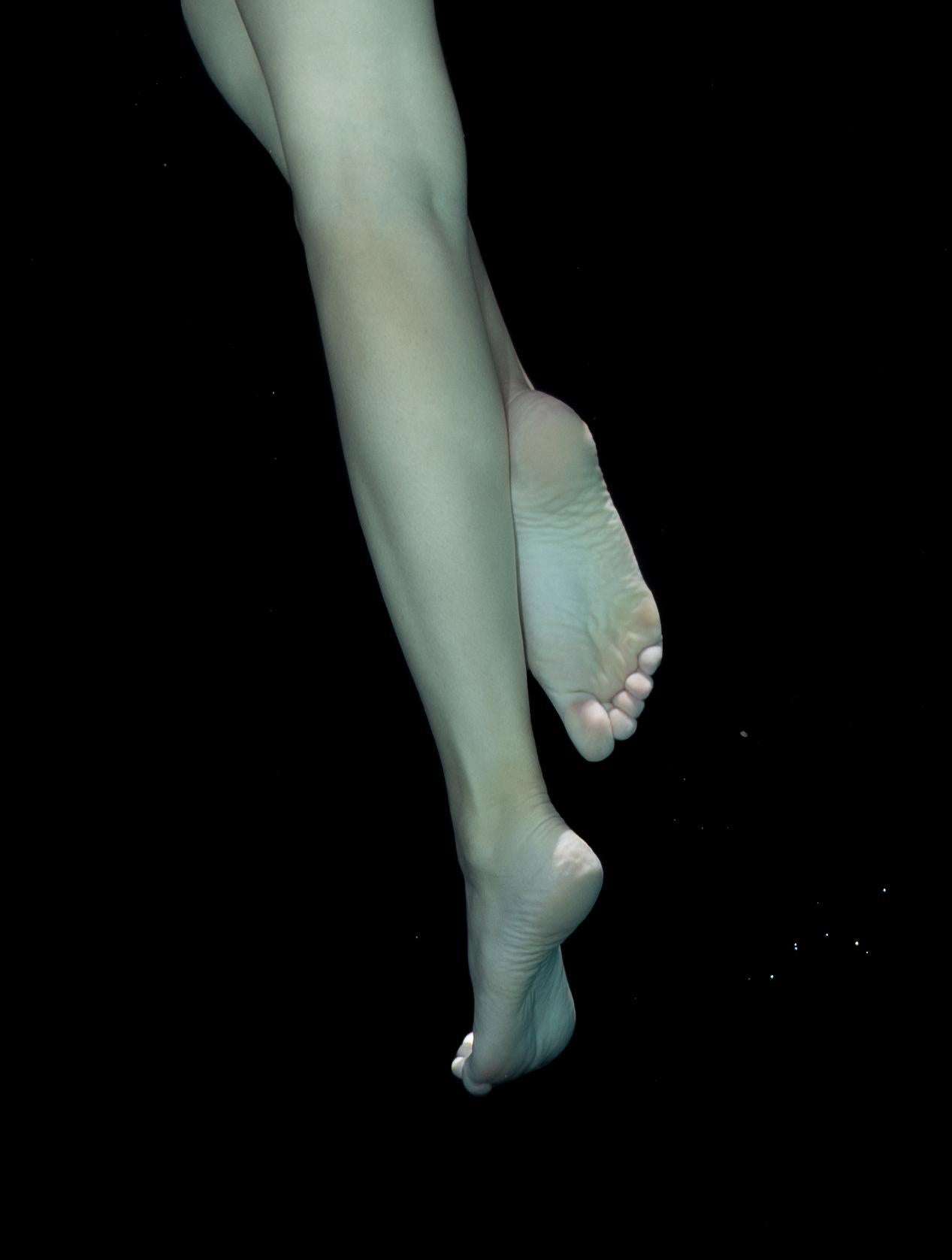 An underwater nude photograph of a young female with black background. The bright red scarf covers model's head and shoulders leaving open her beautiful butt and legs.

Original gallery quality archival pigment print signed by the artist.
Limited