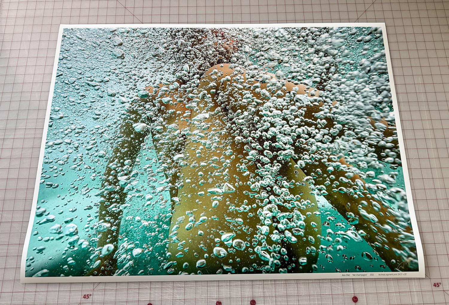 Photographie sous-marine d'une jeune femme nue enveloppée de bulles. Il s'agit d'un  photographie lumineuse de haute résolution avec de riches tons verts et dorés migrant vers le bleu et l'orange.

Tirage pigmentaire original de qualité galerie
