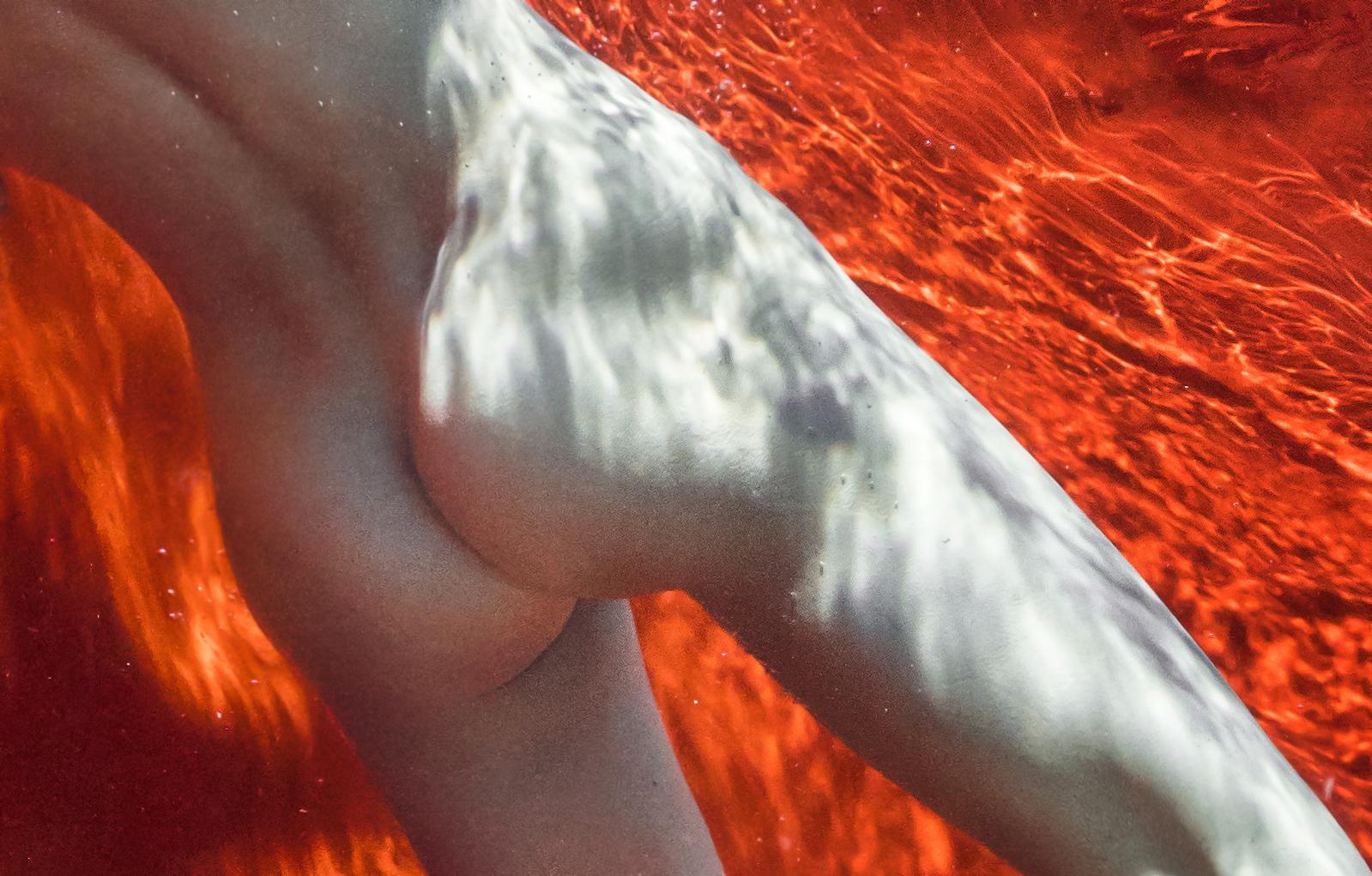 Ein Unterwasserfoto einer nackten jungen Frau, die in einem Pool vor einem leuchtend roten Hintergrund taucht.

Für Glück gibt es keine Regeln.  Ich war mir sicher, dass das neue Mädchen viel Übung brauchen würde - und lag falsch. Sie war einfach