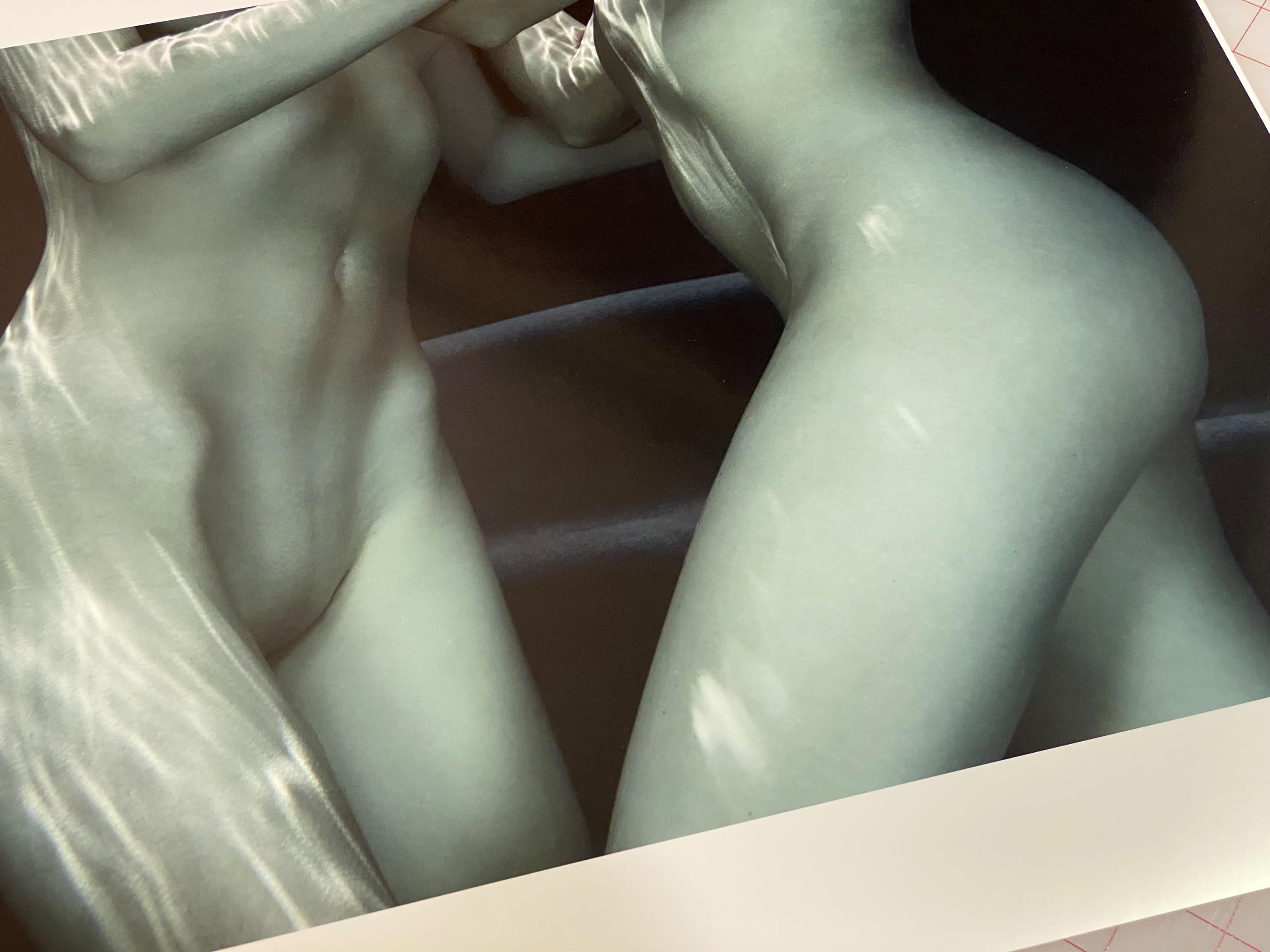 Photographie sous-marine de deux jeunes femmes nues dans une piscine. La photographie minimaliste représente partiellement des corps dans un schéma de couleurs bleues.

Impression originale de qualité galerie signée par l'artiste. 
Impression