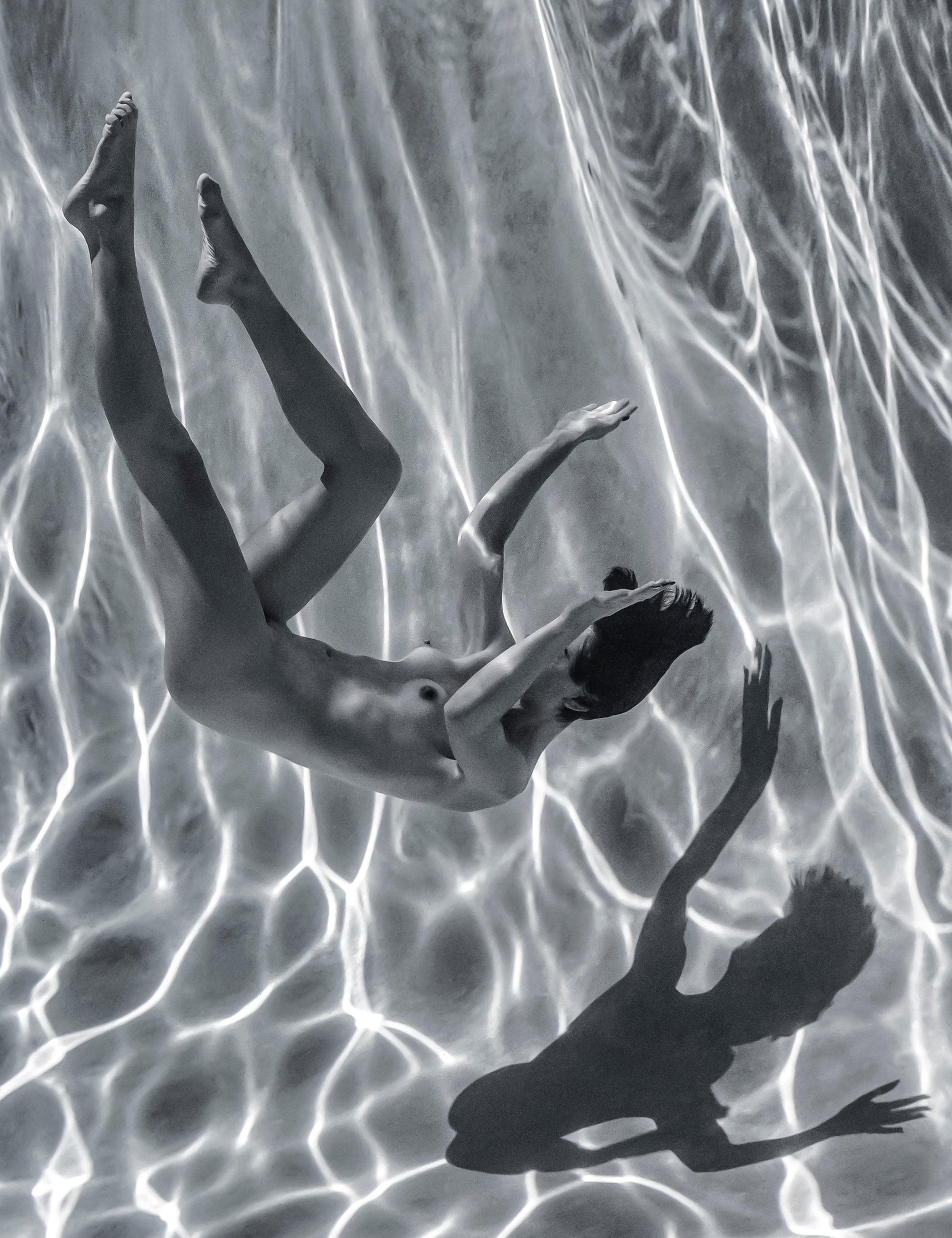 Underwater black and white photograph of a naked young woman in a pool. 

Original digital print on aluminum plate with black backboard - signed by the artist.
The artwork needs no additional framing: it can be hung and it can stand on a surface.