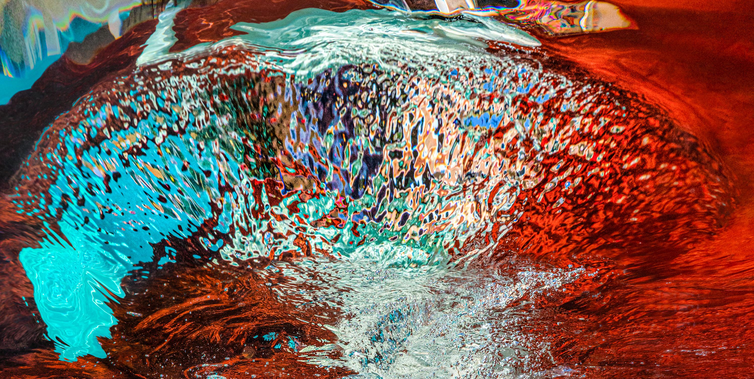 Ein Unterwasser-Aktfoto von einer schönen jungen Frau, die in einem roten Pool taucht.  Wellen und Sonnenstrahlen malen geheimnisvolle Muster auf ihre perfekten Brüste.

Original-Pigmentdruck in Galeriequalität, vom Künstler signiert.
Limitierte