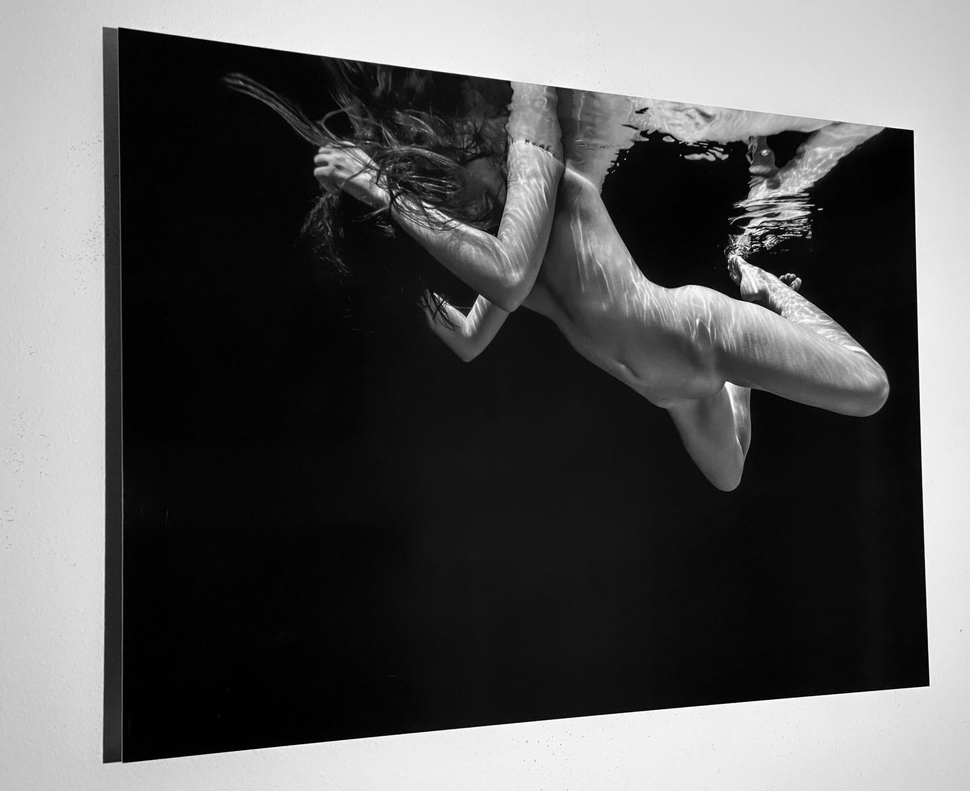 Unterwasser-Schwarz-Weiß-Foto einer nackten jungen Frau, die in die Kamera lächelt. 
Dieses minimalistische Foto passt gut zu einer Vielzahl von Interieurs.

Original-Digitaldruck auf Aluminiumplatte, vom Künstler signiert.
Limitierte Auflage von 12