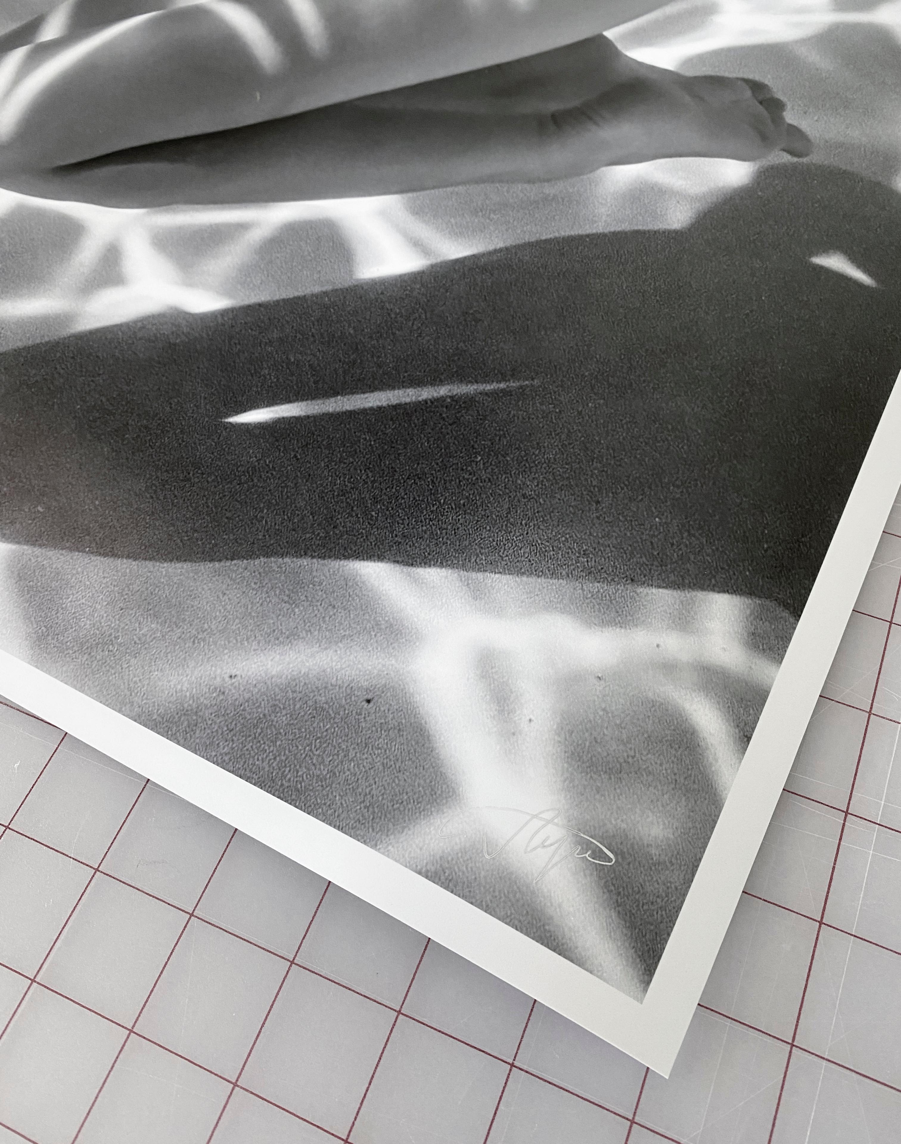 An underwater black and white photograph of a beautiful naked model on her knees at the bottom of the pool.

Original gallery quality archival pigment print signed by the artist.
Limited edition of 24.
paper size: 66x44