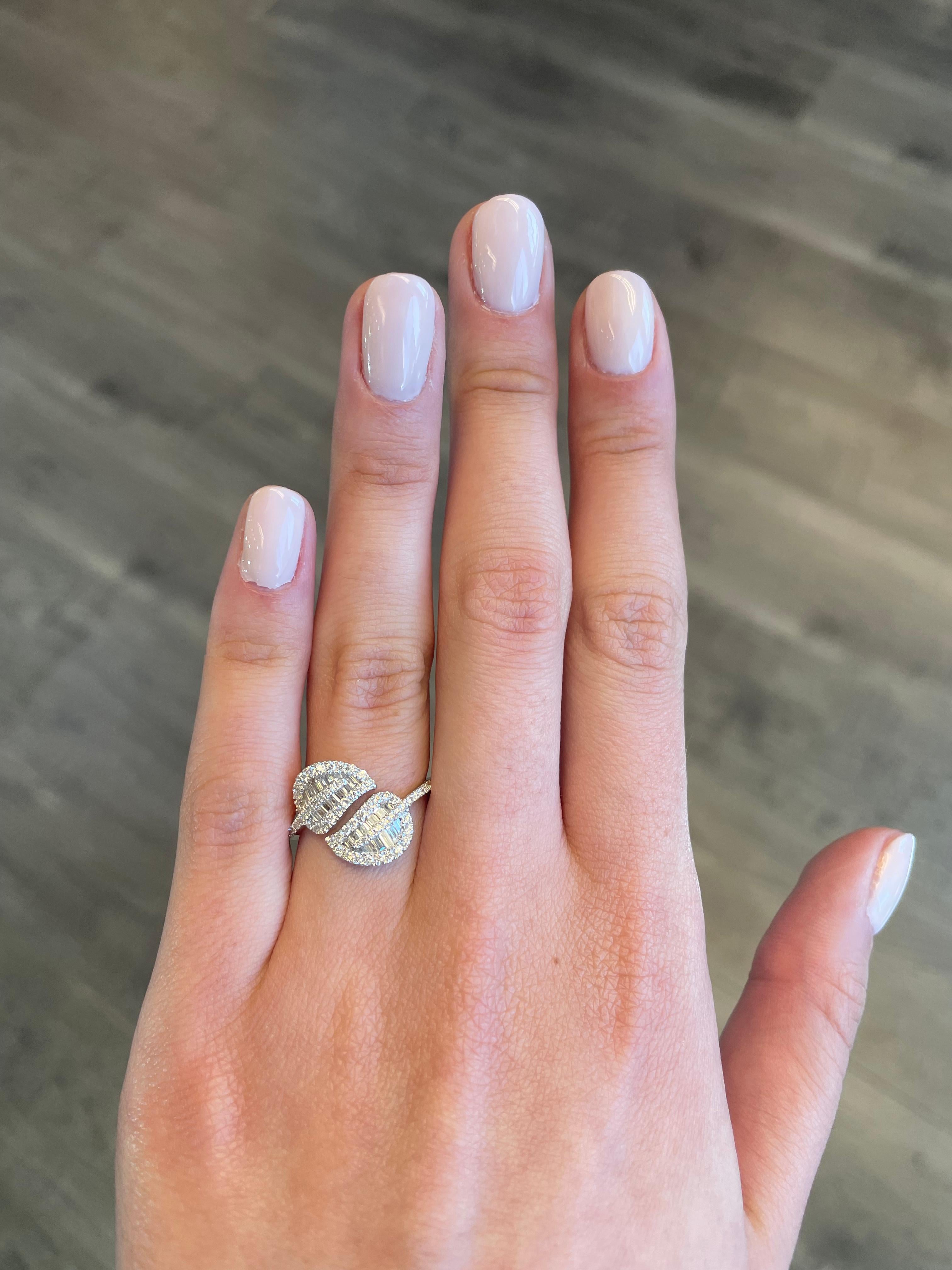 Stunning modern leaf motif bypass ring, by Alexander Beverly Hills.
100 round and baguette cut diamonds, 0.81 carats. Approximately G color grade and VS clarity grade. 18-karat white gold, 3.11 grams, current ring size 6.75.
Accommodated with an