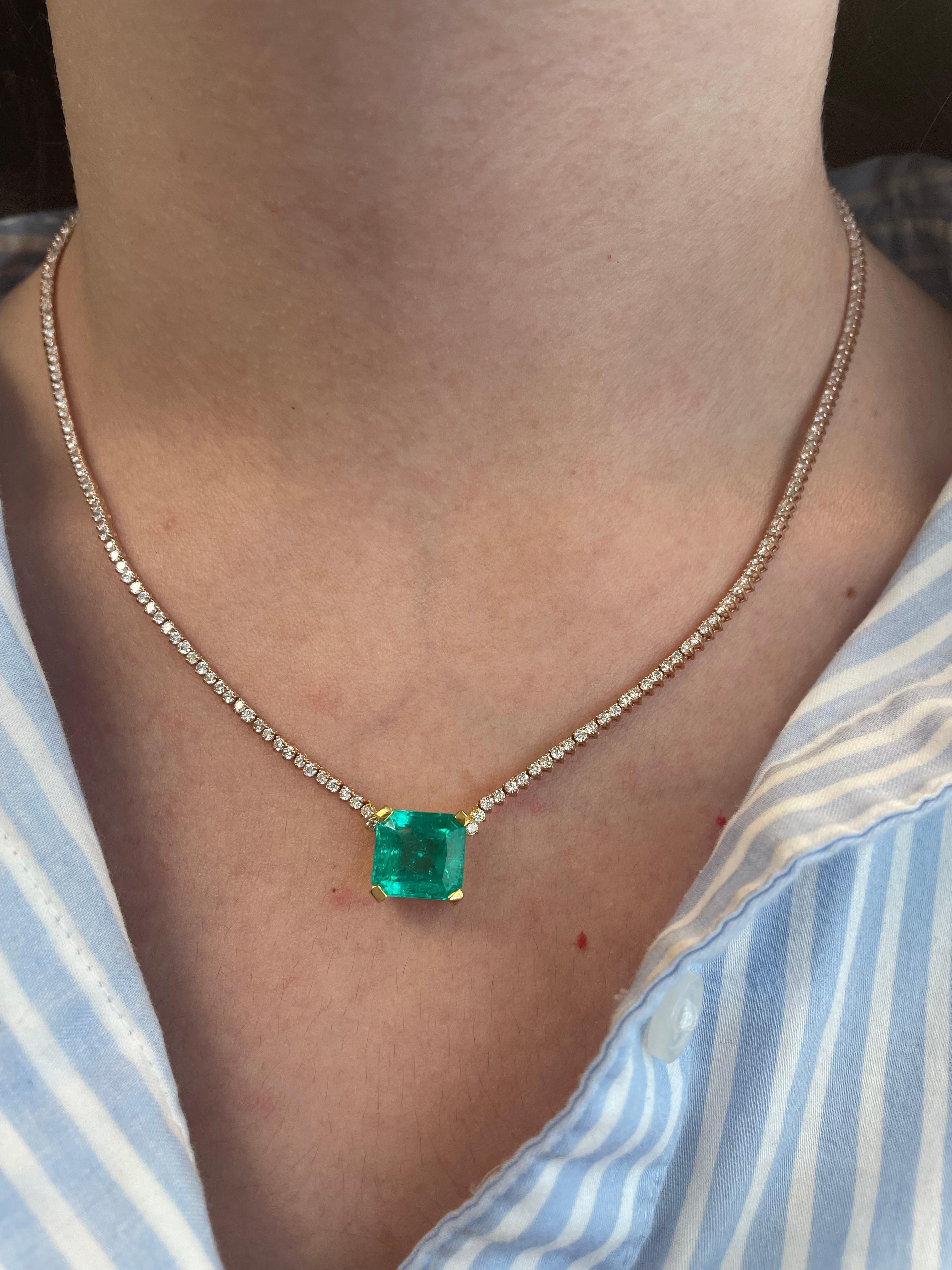 Modern diamond tennis necklace with a Colombian emerald center stone.
6.12 carat emerald cut Colombian emerald, apx F2. 236 round brilliant diamonds, 3.99 carats. Approximately H/I color and SI clarity. 18k rose & yellow gold, 11.22 grams,