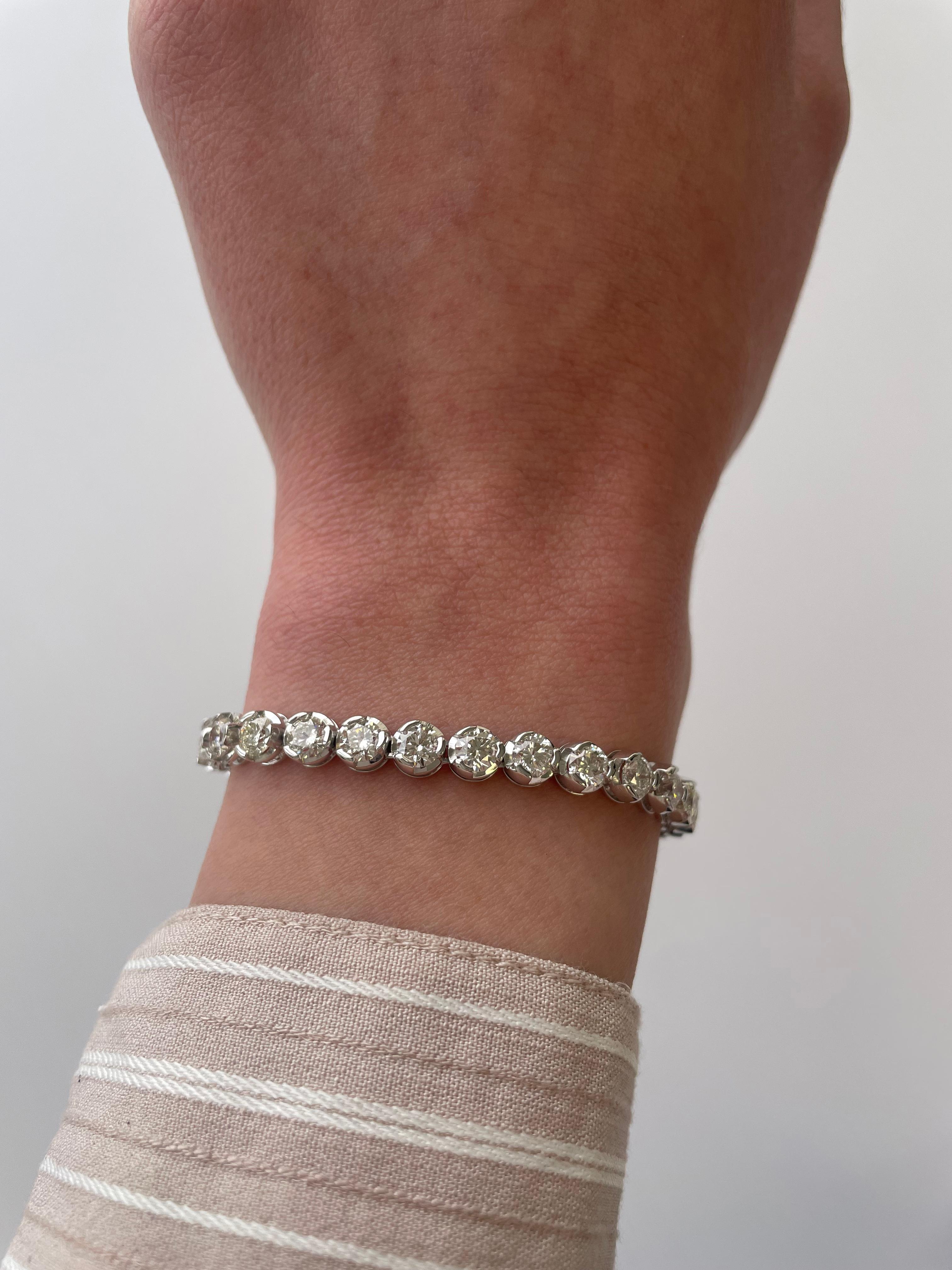 Exquisite and timeless illusion set diamonds tennis bracelet, by Alexander Beverly Hills.
33 round brilliant diamonds, 10.14 carats total. Approximately G/H color and VS clarity. Four prong set in 18k white gold, 16.42 grams, 7.25 inches.