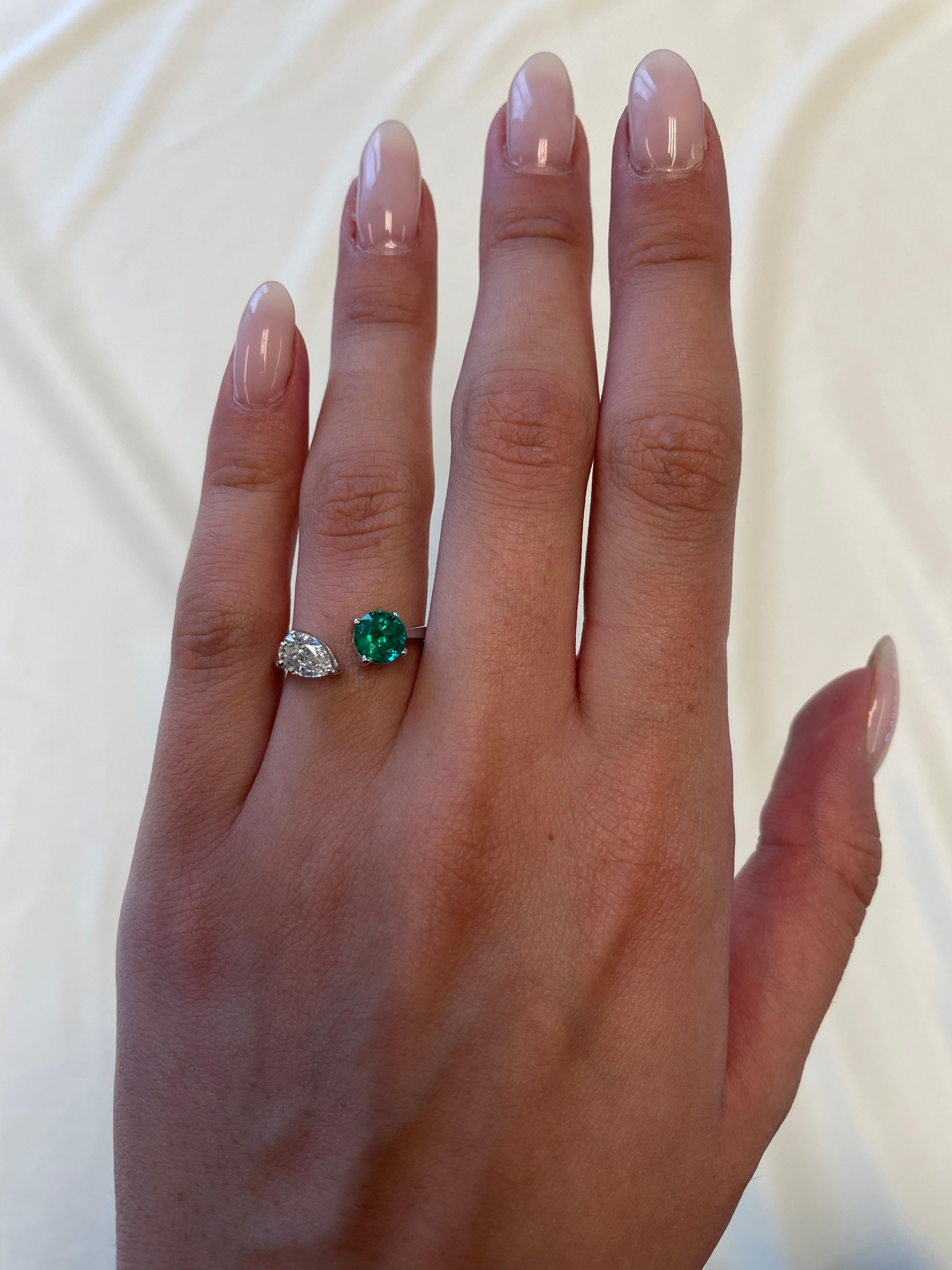 Stunning modern floating emerald and diamond toi et moi ring. By Alexander Beverly Hills.
1.42 carats total gemstone weight.
0.89 carat round shape emerald. 0.53 carat pear shape diamond, approximately G/H color, and SI clarity. 18-karat white gold,