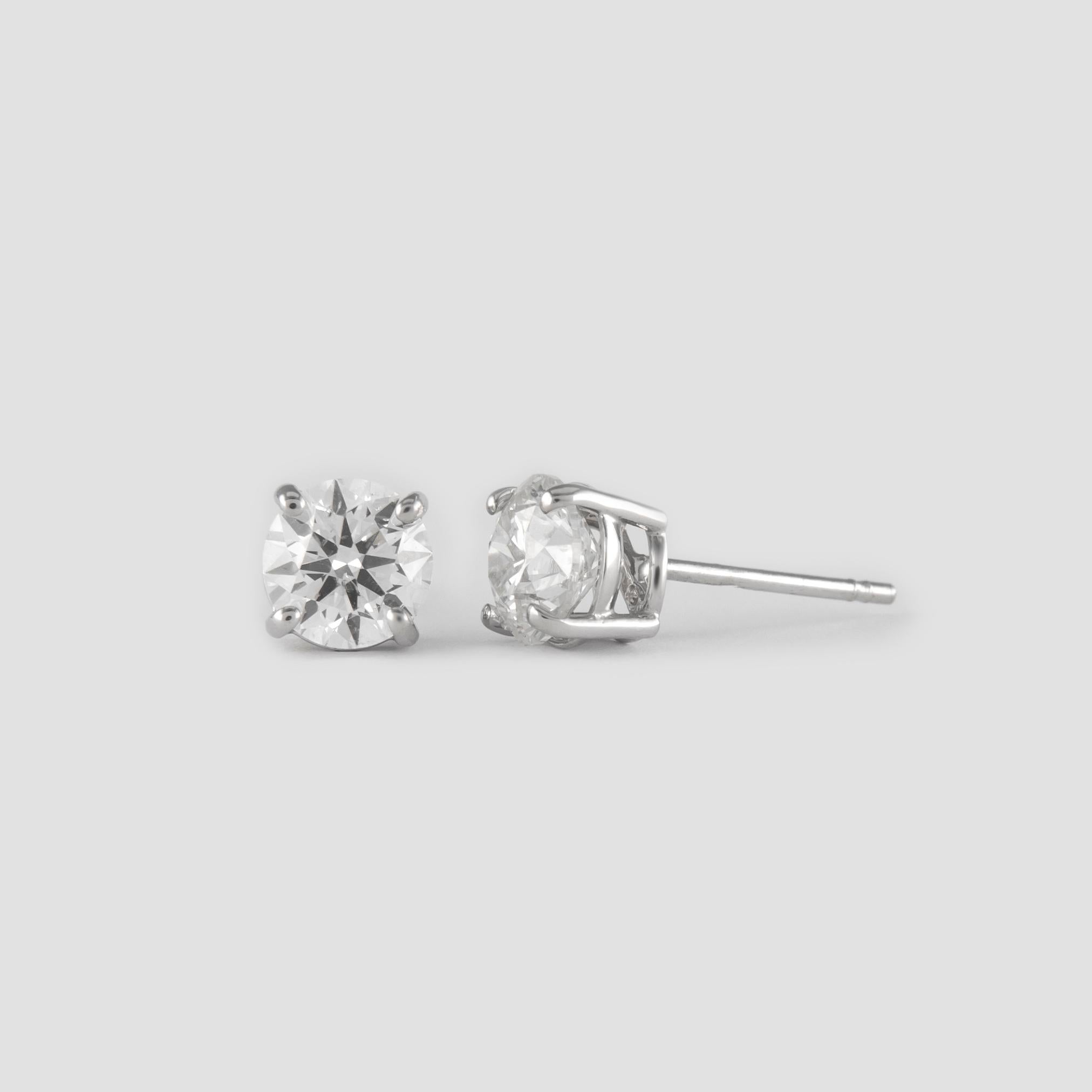 Classic diamond stud earrings. By Alexander of Beverly Hills.
Two round brilliant diamonds 1.46 carats total. Approximately G color and SI clarity. Four prong set, 14k white gold. 
Accommodated with an up to date appraisal by a GIA G.G., please