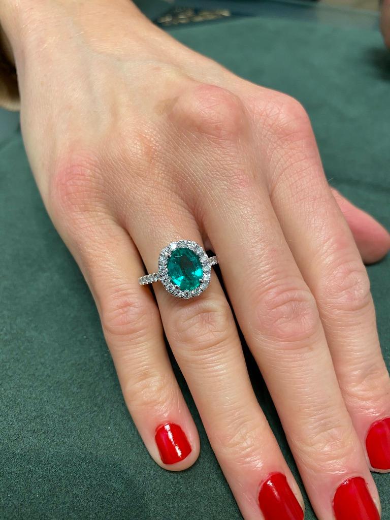 Lovely emerald with diamond halo ring. By Alexander of Beverly Hills.
1.97 carat oval emerald complimented with 28 round brilliant diamonds, 0.76ct. Approximately G/H color and VS2/SI1 clarity. 2.73ct total gemstone weight, in 18k white gold.