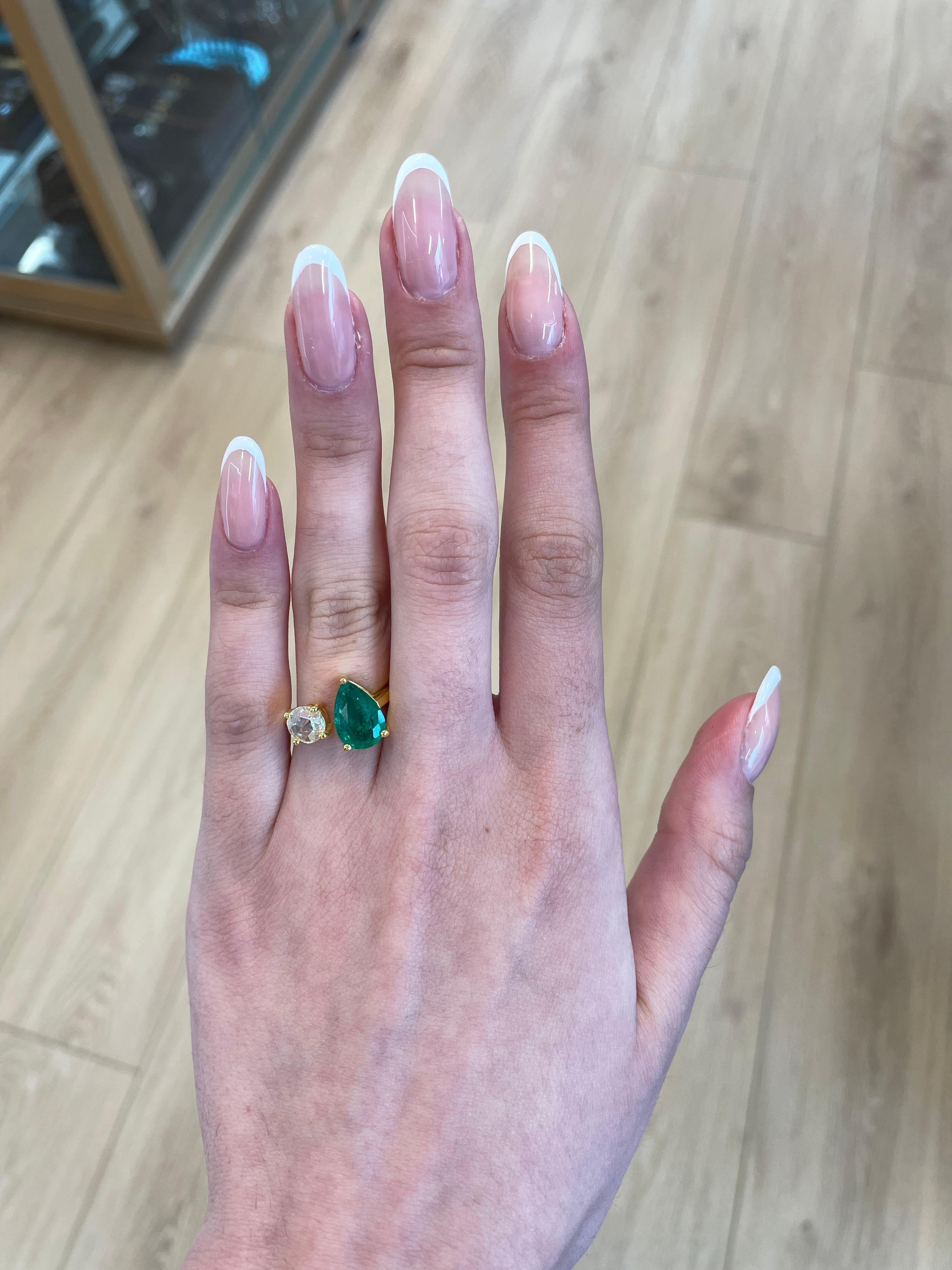 Stunning modern floating emerald and diamond toi et moi ring. By Alexander Beverly Hills.
1 pear shape emeralds, 1.93 carats apx F2. 1 round rose cut diamond 0.56 carats, approximately G/H color and VS clarity. 18-karat yellow gold, 4.97 grams,