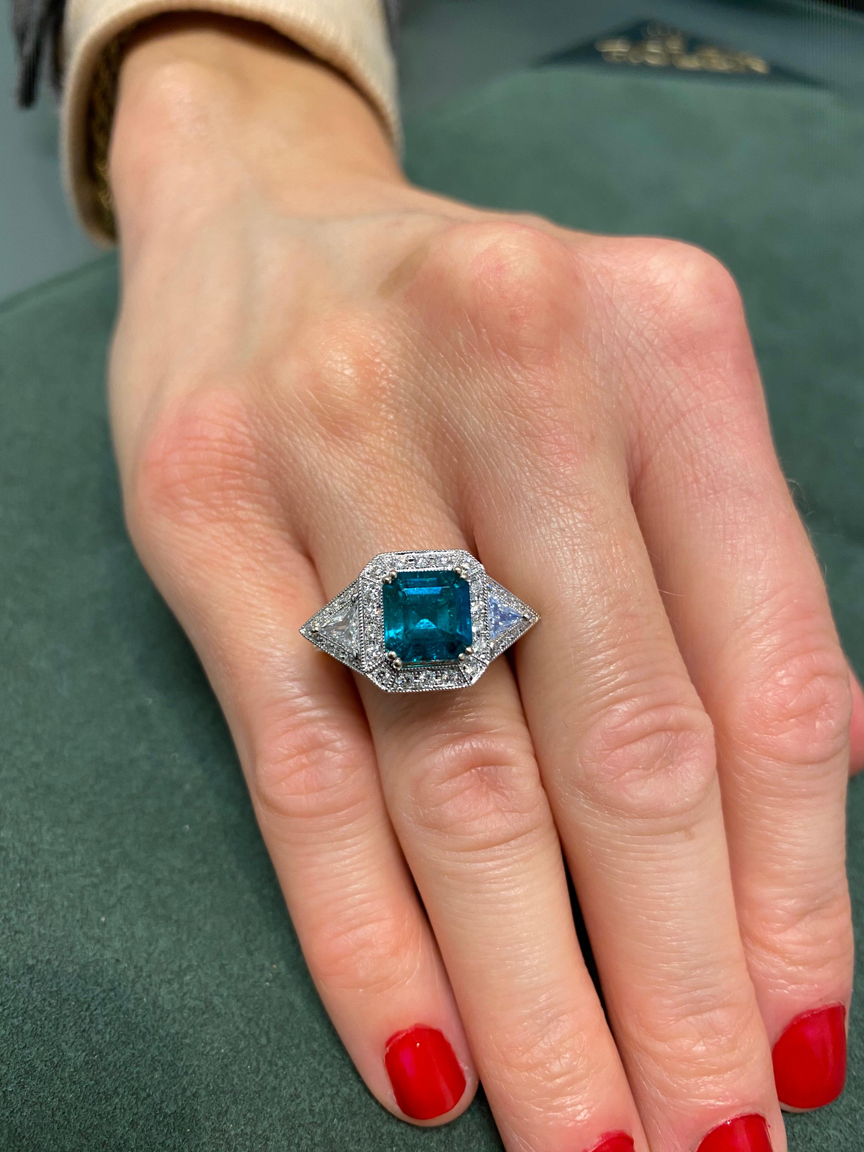 Exquisite emerald and diamond three stone / halo ring. High jewelry by Alexander Beverly Hills.
2.50 carat emerald cut emerald, apx F2. Complimented with round brilliant and trilliant diamonds, approximately G/H color and SI clarity. 3.69ct total