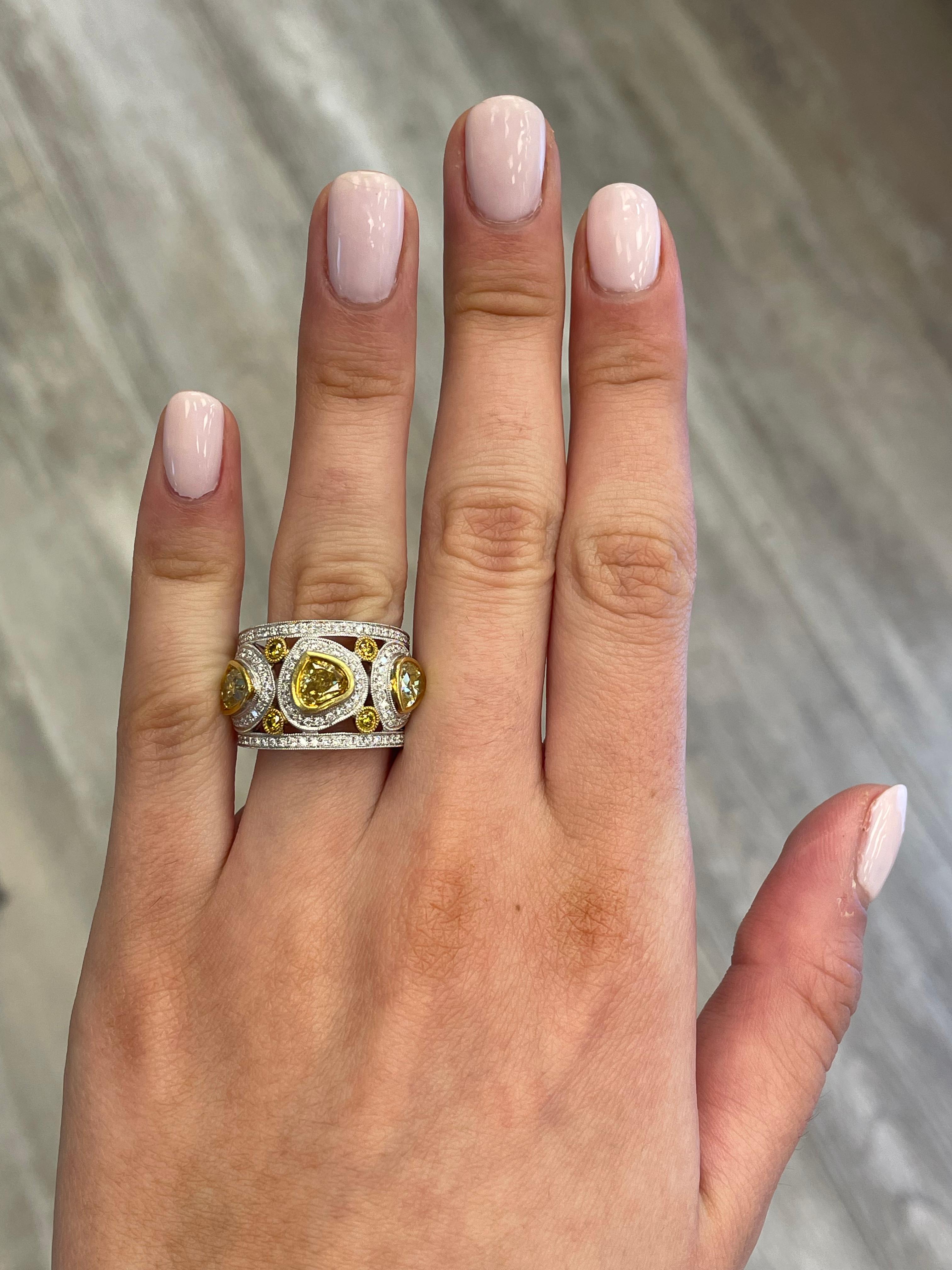 Stunning 3 yellow diamonds bezel set ring with two rows of round diamonds and millgrain, EGL certified. By Alexander Beverly Hills. 
2.58 carats total diamond weight.
Center heart shape diamonds approximately fancy intense brownish yellow. 2
