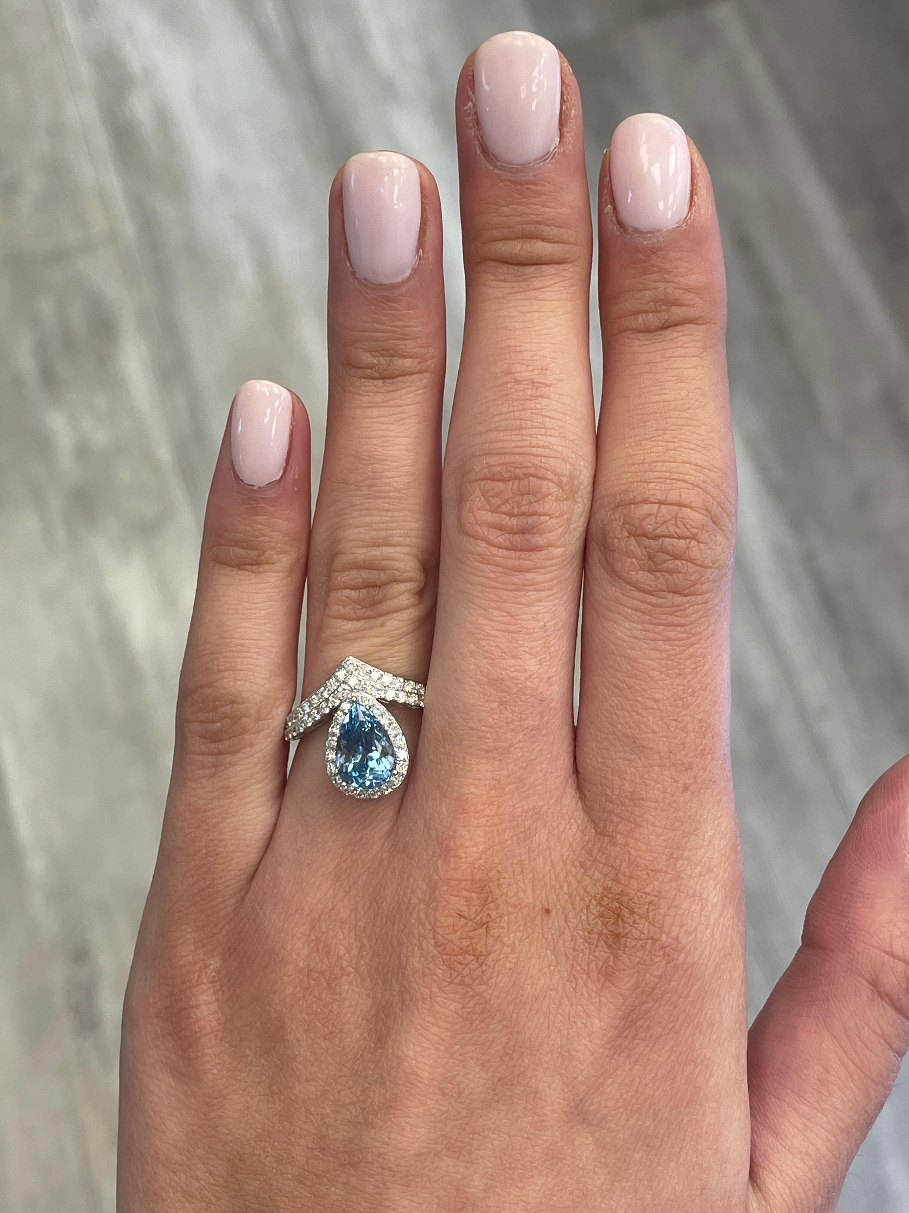 Stunning aquamarine and diamond ring with halo, by Alexander Beverly Hills.
1 pear aquamarine, 2.03 carats. Complimented by 62 round brilliant diamonds, 0.63 carats. Approximately D-F color and SI clarity. 18-karat white gold, 4.04 grams, 6 ring