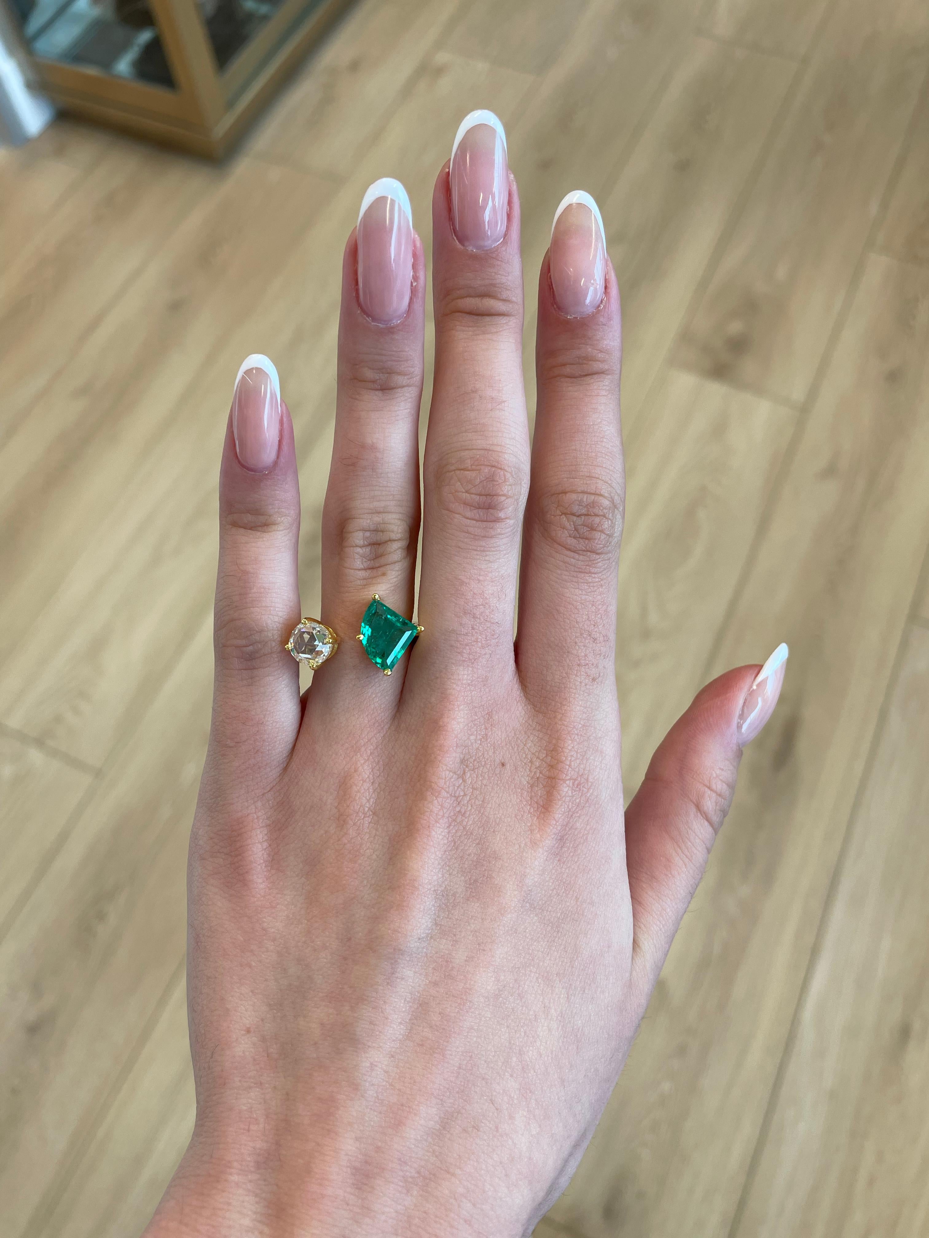 Stunning modern floating emerald and diamond toi et moi ring. By Alexander Beverly Hills.
1 kite shape emeralds, 1.79 carats apx F2. 1 round rose cut diamond 1.32 carats, approximately G/H color and VS clarity. 18-karat yellow gold, 6.28 grams,