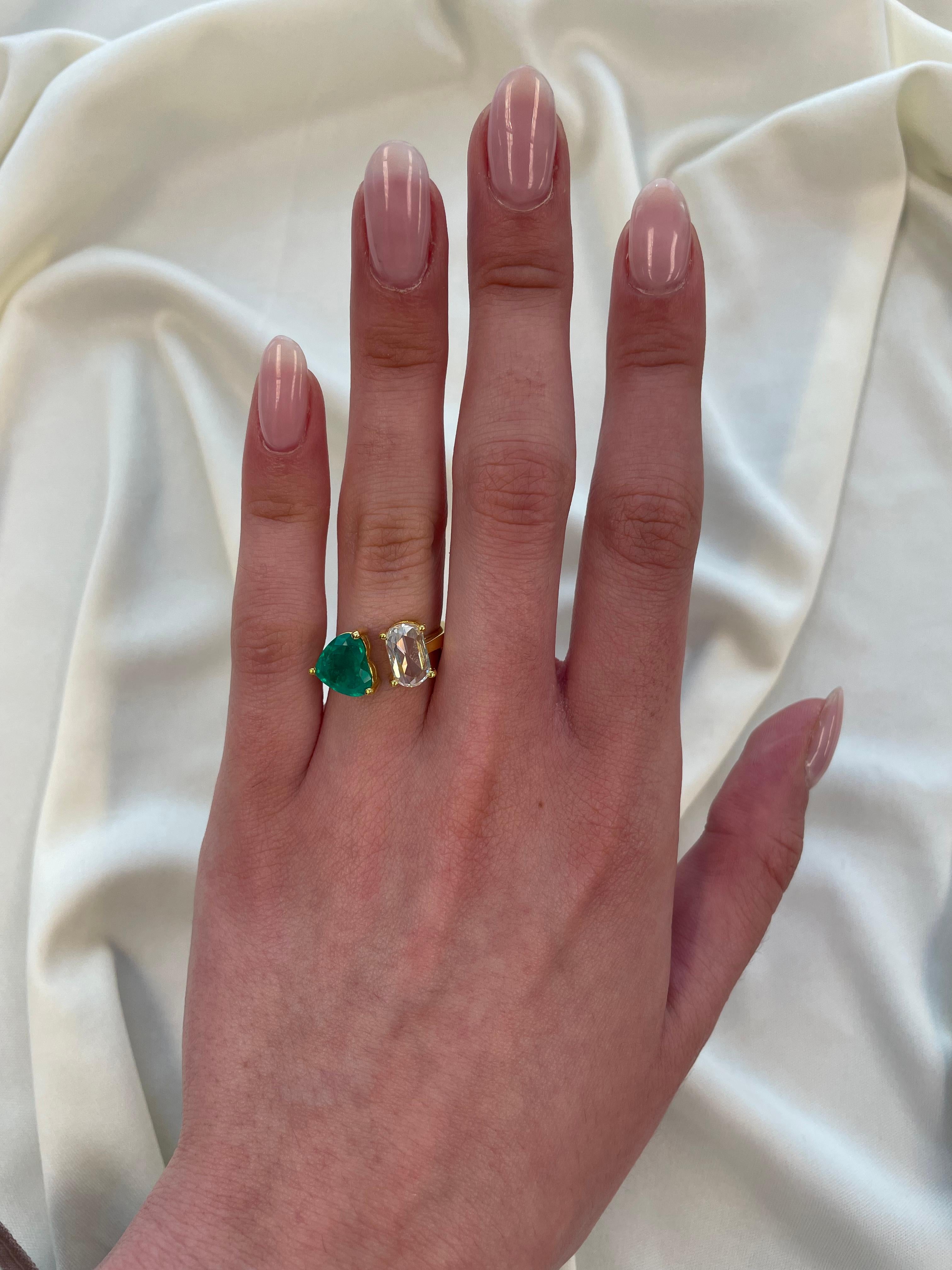 Stunning modern floating emerald and diamond toi et moi ring. By Alexander Beverly Hills.
1 heart shape emeralds, 1.79 carats apx F2. 1 oval rose cut diamond 1.32 carats, approximately G/H color and vs clarity. 18-karat yellow gold, 5.42 grams,