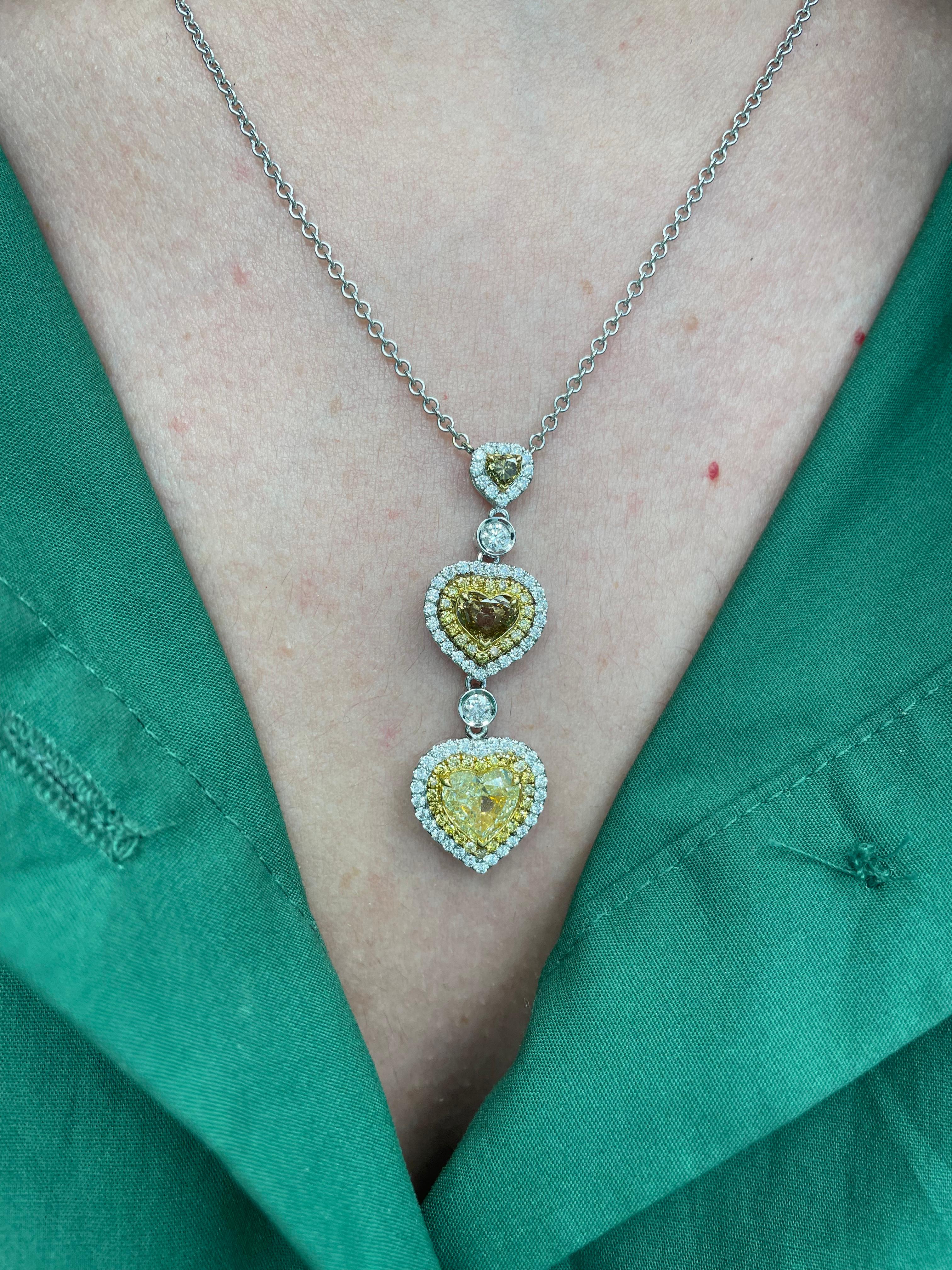 Exquis collier pendentif en forme de cœur en diamants de couleur fantaisie avec double halos de diamants, par Alexander Beverly Hills.
3 diamants en forme de cœur de couleur jaune fantaisie à brun fantaisie, 3,54ct. Complété par 0,78 carats de