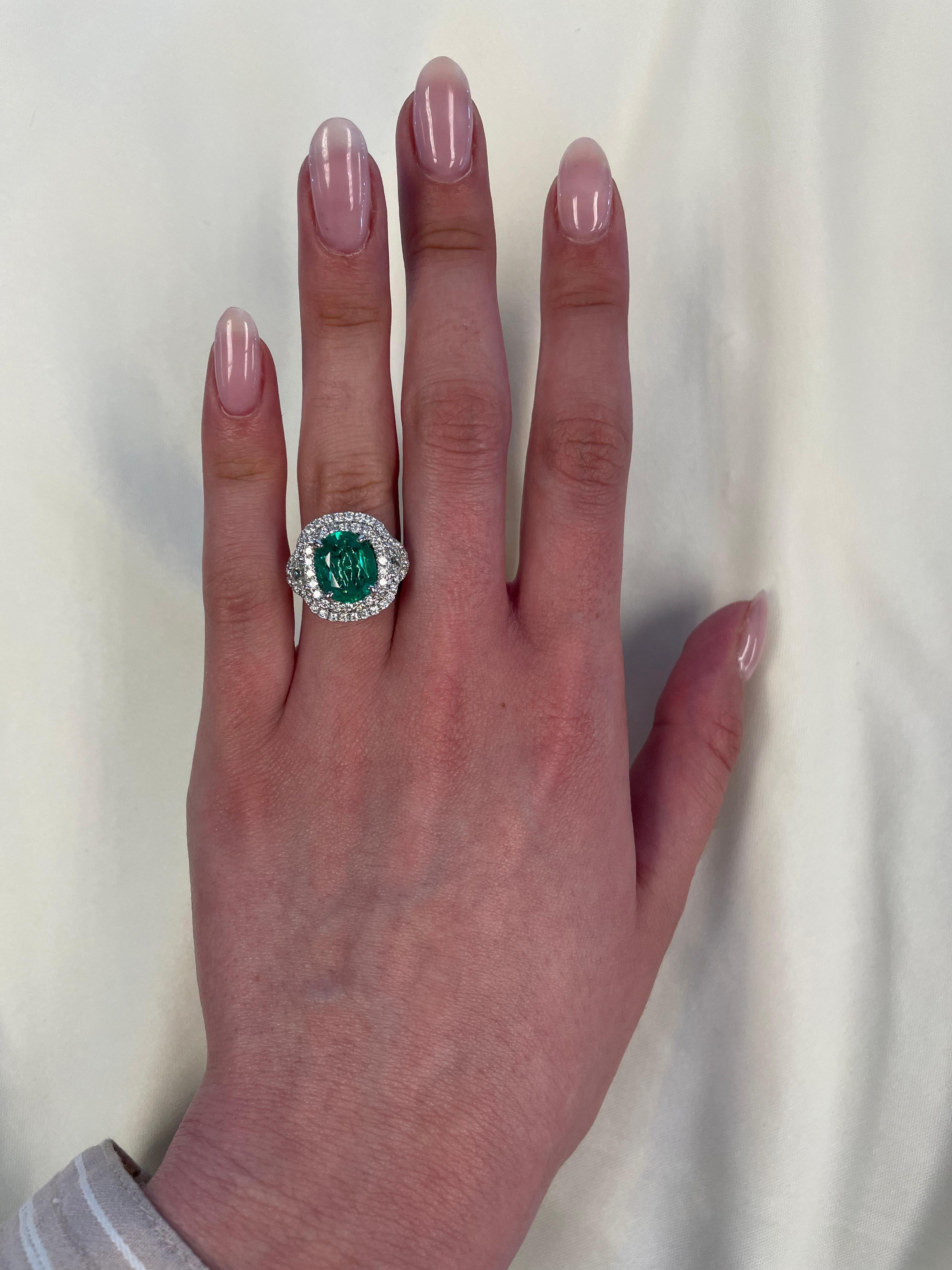 Stunning emerald and diamond three stone ring with halo. By Alexander of Beverly Hills. 
Superb color.
4.36 carats total gemstone weight.
2.63 carat oval emerald. 2 half moons with round brilliant diamonds, 1.73 carats. Approximately G/H color and