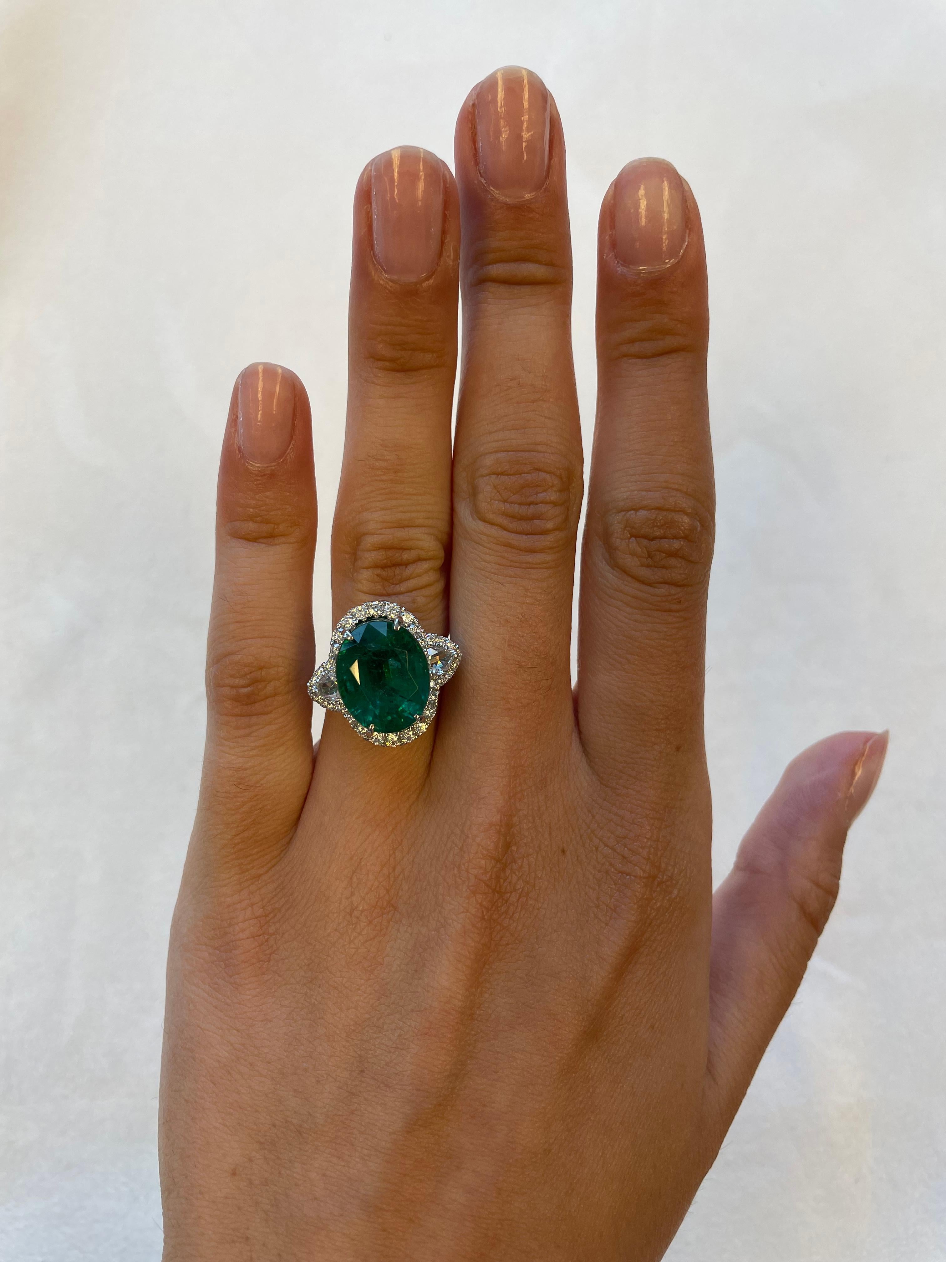 Stunning emerald and diamond three stone ring with halo. 
9.60 carats total gemstone weight.
8.50 carat oval emerald, apx F2. 2 pear rose cuts with 46 round brilliant diamonds, 1.10 carats. Approximately G/H color and VS1-SI1 clarity. 18k white