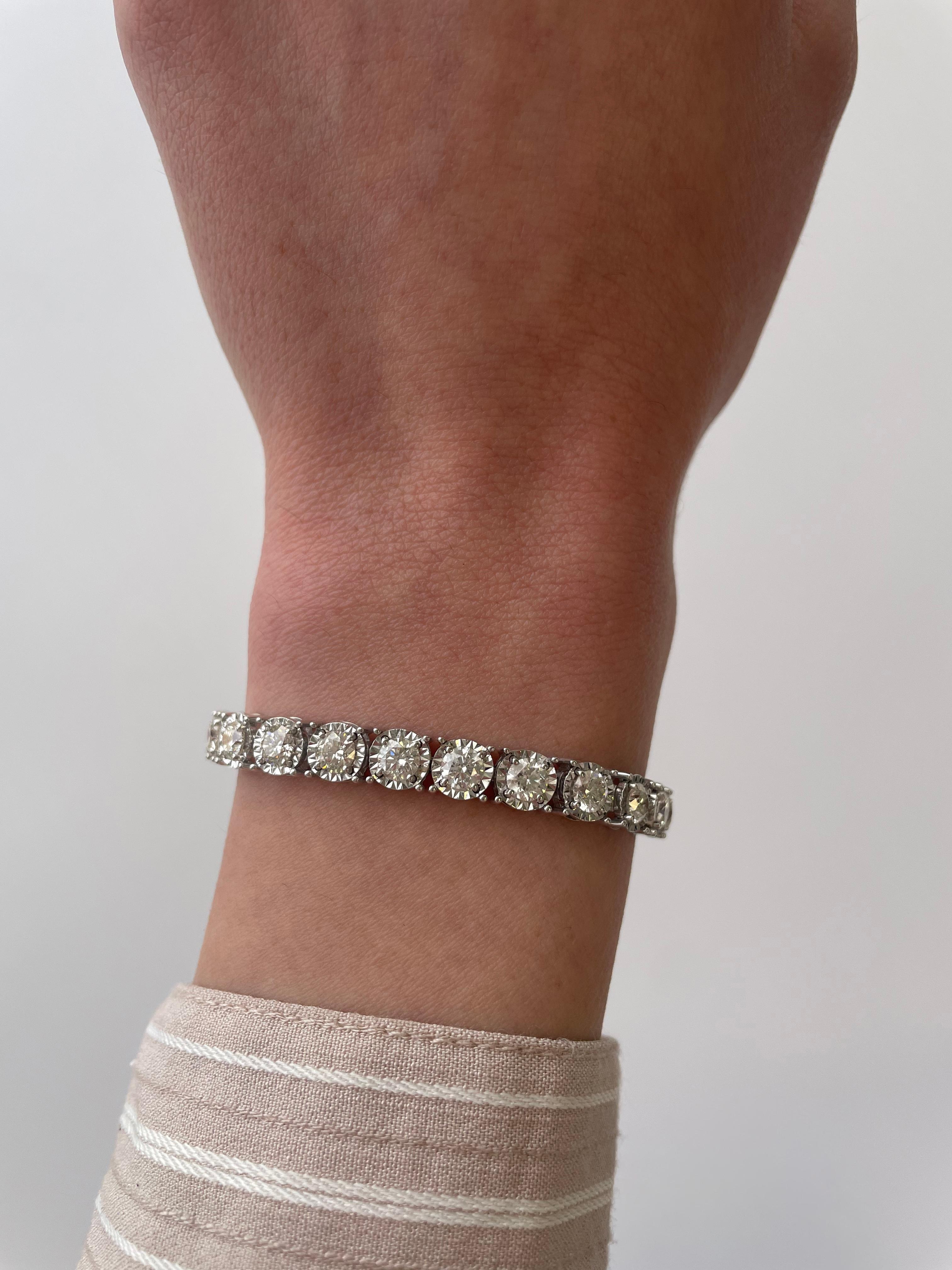 Exquisite and timeless illusion set diamonds tennis bracelet, by Alexander Beverly Hills.
27 round brilliant diamonds, 8.82 carats total. Approximately G/H color and VS clarity. Four prong set in 18k white gold, 19.11 grams, 7 inches. 
Accommodated