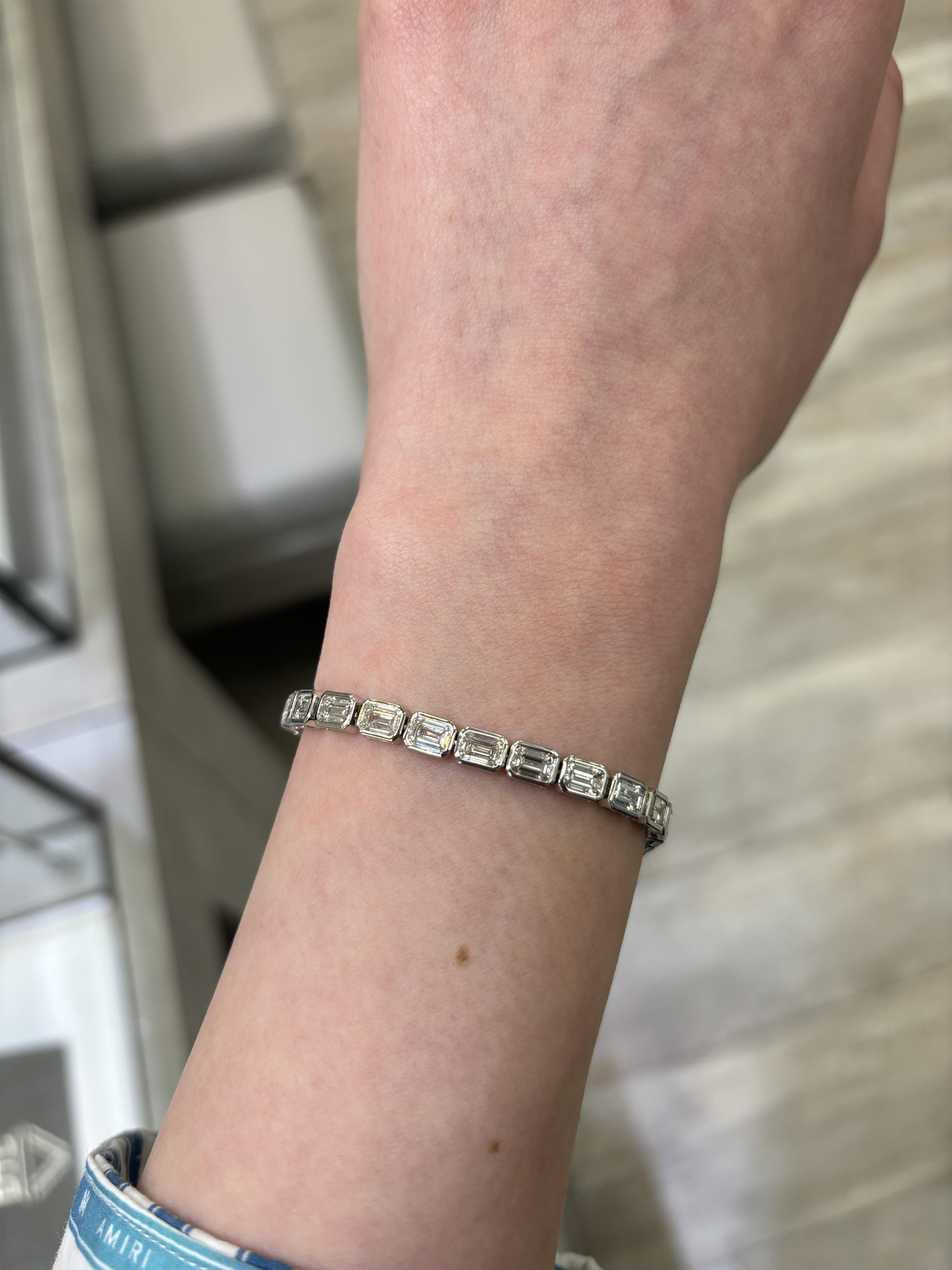 Stunning modern east-west bezel set diamond tennis bracelet. High jewelry by Alexander Beverly Hills.
30 emerald cut diamonds, 10.08 carats. Approximately E/F color and VVS1/VVS2 clarity. 18-karat white gold, 11.97 grams, 7 inches.
Accommodated with