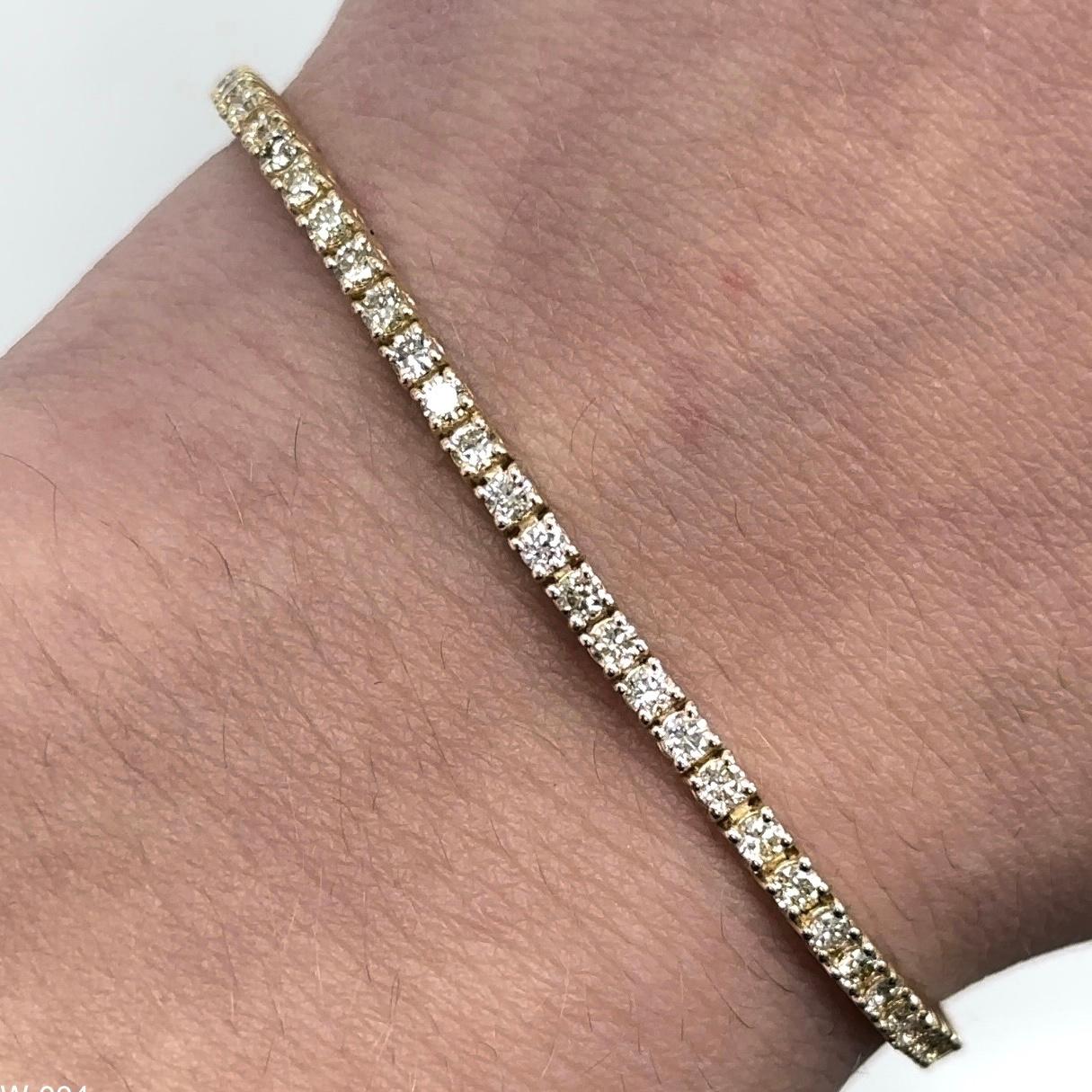 Exquisite and timeless diamonds tennis bracelet, by Alexander Beverly Hills.
90 round brilliant diamonds, 1.28 carats total. Approximately J-L color and SI clarity. Four prong set in 18k yellow gold, 6.19 grams, 7 inches. 
Accommodated with an