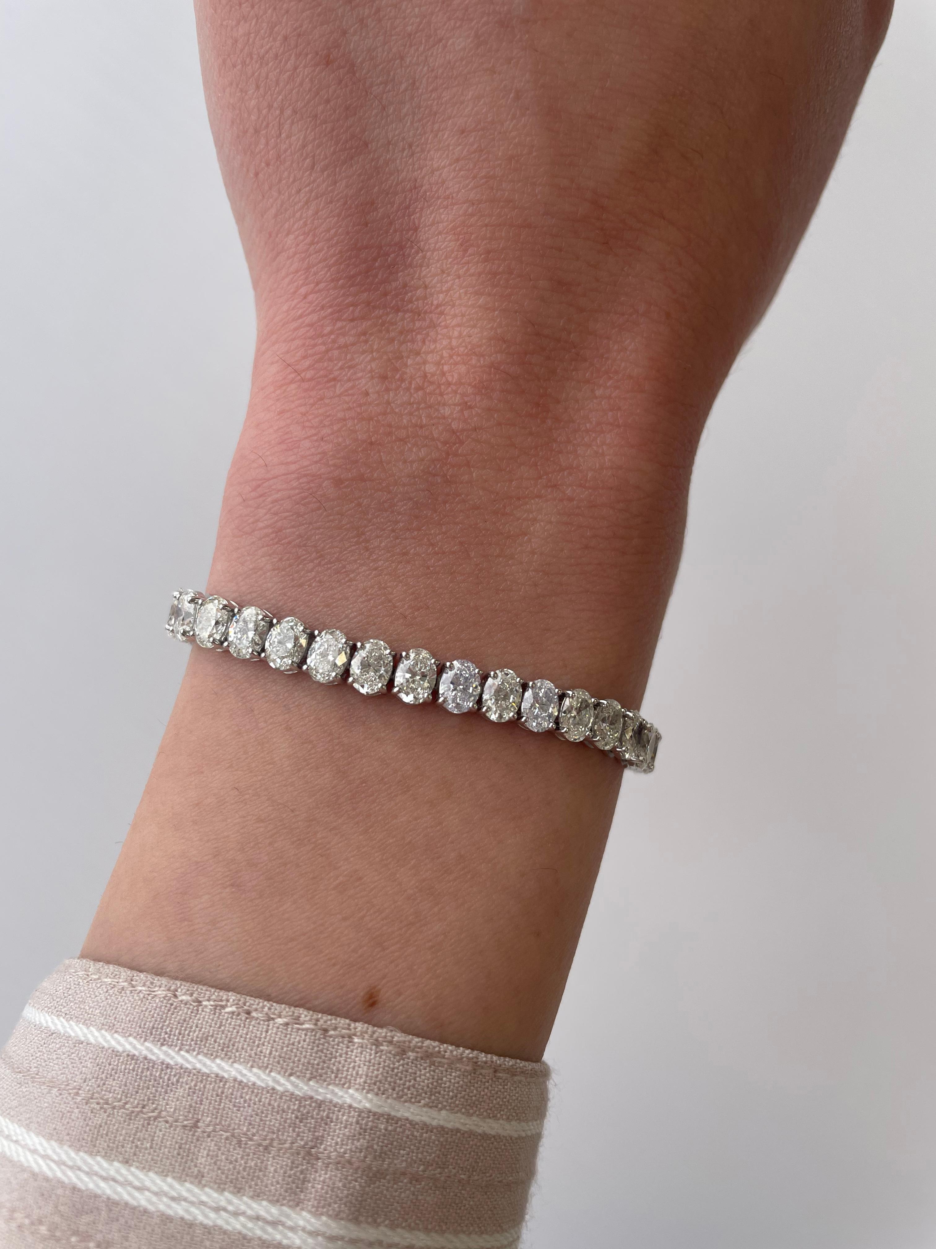 Stunning modern straight oval cut diamond tennis bracelet. High jewelry by Alexander Beverly Hills.
45 oval cut diamonds, 13.65 carats. Approximately H color and SI1 clarity. 18k white gold, 18.17 grams, 7 inches.
Accommodated with an up-to-date