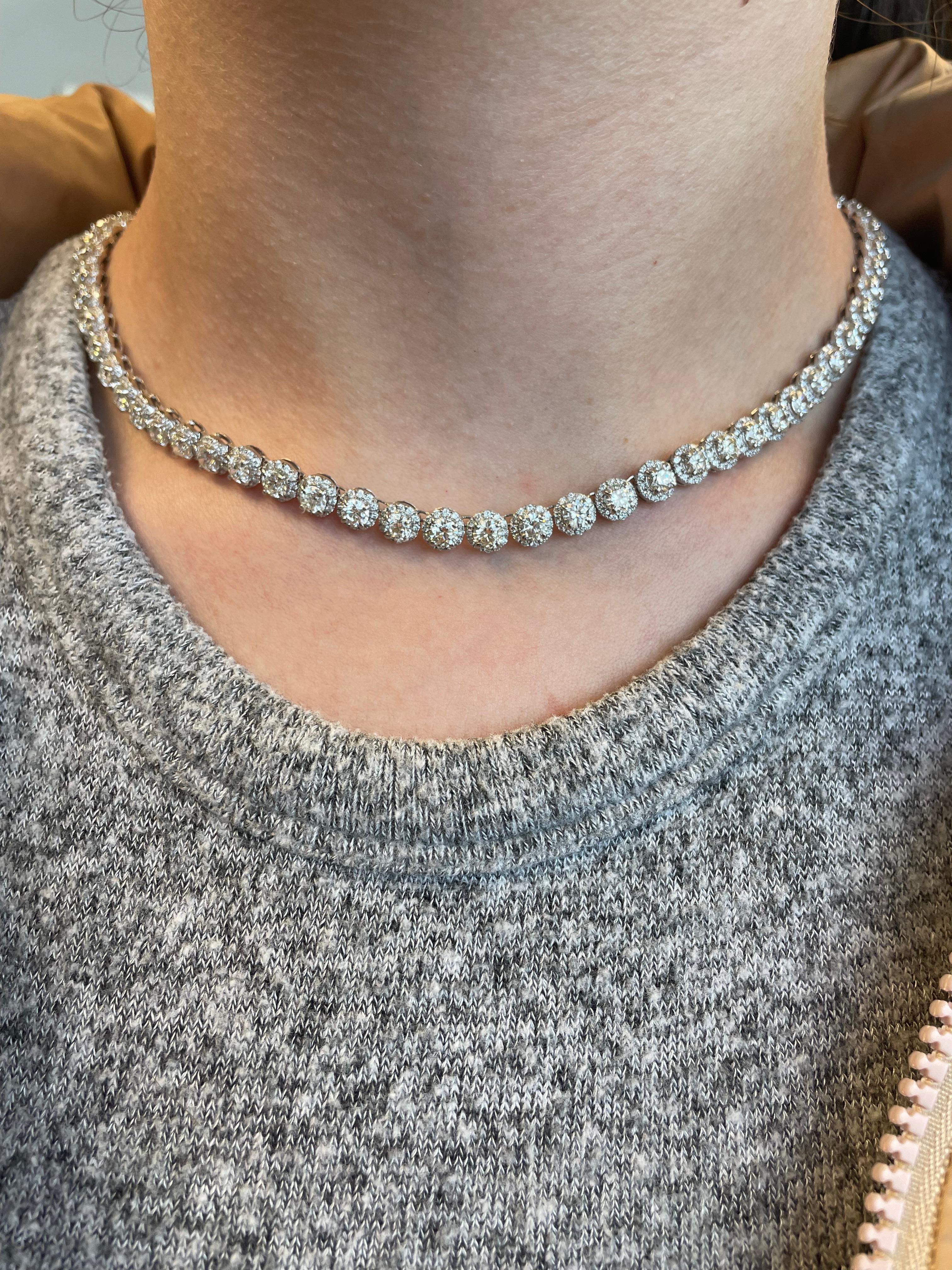 Squisita e intramontabile collana tennis con diamanti naturali e aureola. Alta gioielleria di Alexander Beverly Hills.
67 diamanti tondi brillanti centrali da 16,52 carati completati da un'aureola di diamanti tondi da 4,89 carati, per un totale di