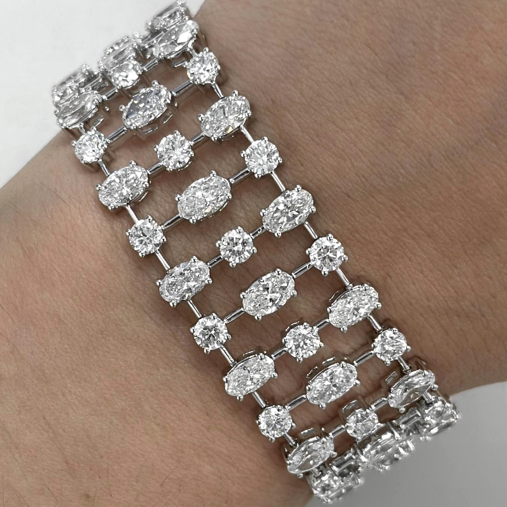 Stunning modern elongated oval cut diamond tennis bracelet with smaller round diamonds. High jewelry by Alexander Beverly Hills.
45 oval cut diamonds, 13.92 carats. Approximately F/G color and SI clarity. Complimented with 45 round diamonds, 8.54