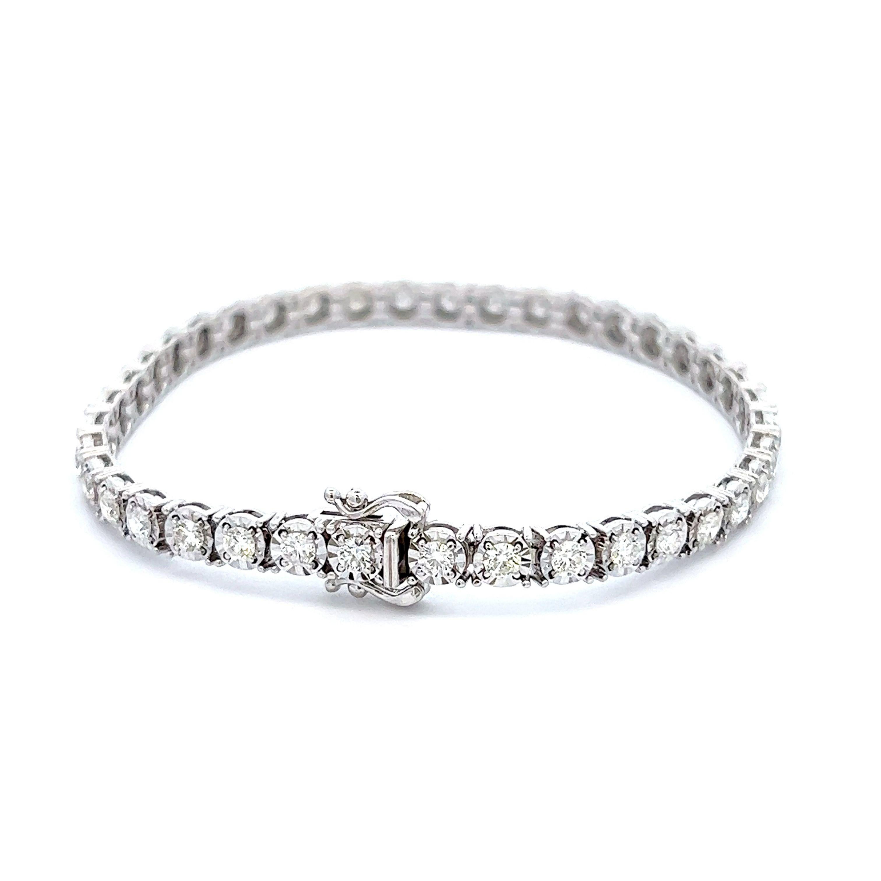 Exquisite and timeless illusion set diamonds tennis bracelet, by Alexander Beverly Hills.
39 round brilliant diamonds, 3.30 carats total. Approximately D-F color and SI clarity. Four prong set in 18k white gold, 13.98 grams, 7 inches. 
Accommodated